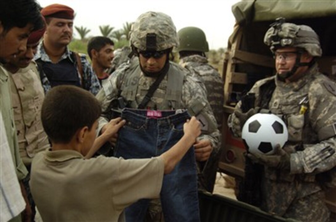 U.S. Army soldiers assigned to the National Police Transition Team, 1st Battalion, 1st Mechanized Brigade hand out clothes, school supplies and toys to children in Al Furat, Iraq, on May 17, 2007.  