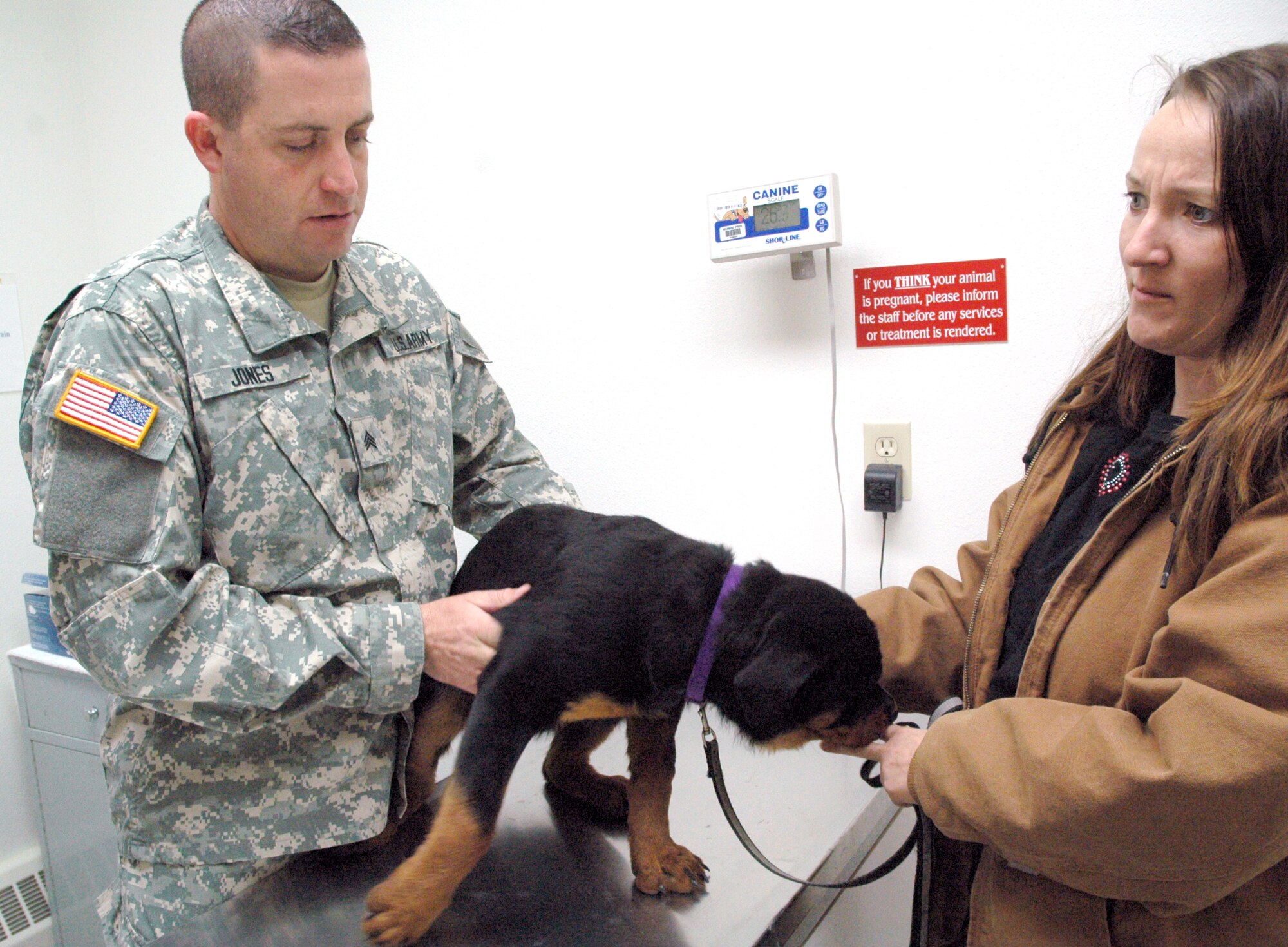 Army Staff Sgt. Daniel Jones, 90th Medical Services Squadron, prepares to apply a pet tracking device to a Warren member's pet dog, Cora (Photo by Airman Alex Martinez).