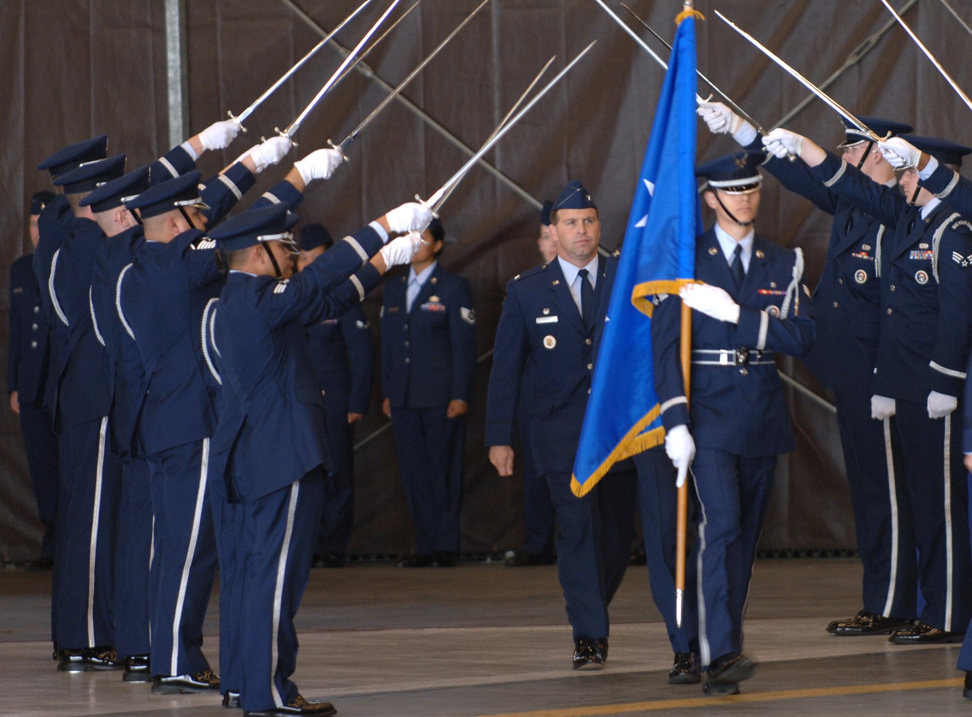 FAIRCHILD AIR FORCE BASE, Wash. – Col. Thomas Sharpy (center, behind flag), 92nd Air Refueling Wing commander, walks through a sword cordon made up of Fairchild Honor Guard members during his assumption of command ceremony here May 22. Colonel Sharpy comes to Fairchild from Travis Air Force Base, Calif., where he served as the 60th Air Mobility Wing vice commander. (U.S. Air Force photo/Senior Airman Chad Watkins)