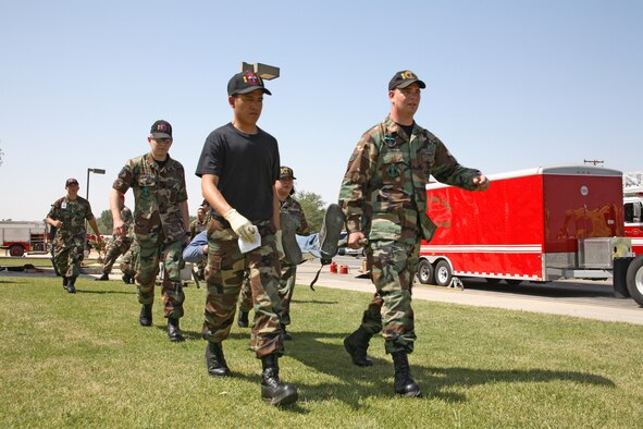 Medics from the 95th Medical Group carry an "injured victim" during the emergency management exercise here May 16. (Photo by Jet Fabara)