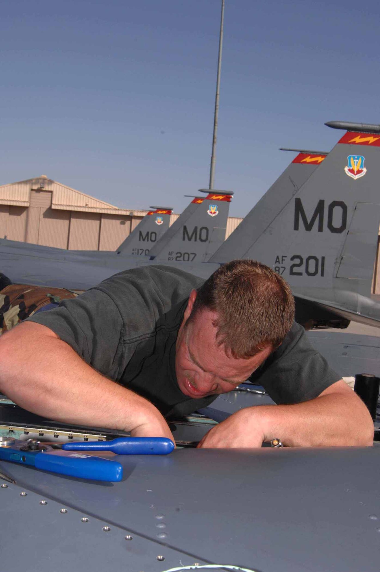 NELLIS AIR FORCE BASE, Nev. -- Tech. Sgt. Eric Burke, an F-15E avionics technician with the 389th Aircraft Maintenance Unit, repairs wiring on top of an F-15E Strike Eagle during maintenance operations May 18 at Nellis Air Force Base. Aircrews and maintenance troops from the 389th and 391st Fighter Squadrons and 389th and 391st AMUs at Mountain Home Air Force Base traveled to Nellis earlier this month to complete a week-long weapons instructor course. The temporary duty assignment became the first for the 389th FS since becoming an F-15E Strike Eagle squadron in March. (U.S Air Force photo/Senior Airman Larry E. Reid Jr.)