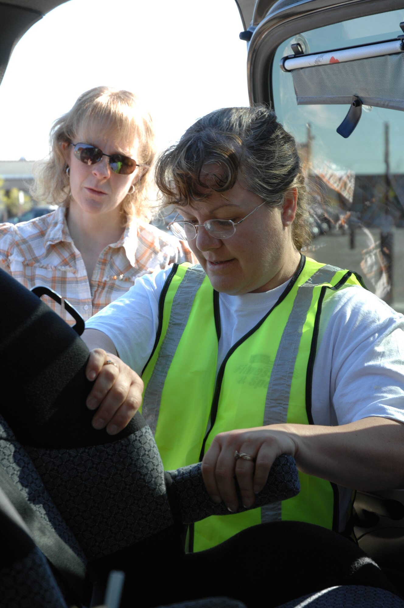 EIELSON AIR FORCE BASE, Alaska -- Jenni Osborne, Health and Wellness Center national passenger safety technician, conducts a car-seat safety inspection for Mrs. Michelle Dachel and members of Eielson AFB during Police Week May 19. Police Week is an annual event hosted by the 354th Security Forces Squadron in honor of National Police Week. Among many of the activities during the week is making sure parents are aware of the many dangers facing improper car seat installation.  Of the 21 car seats inspected, 13 were improperly installed; therefore 13 potential lives were saved. (U.S. Air Force photo by Staff Sgt. Tia Schroeder)