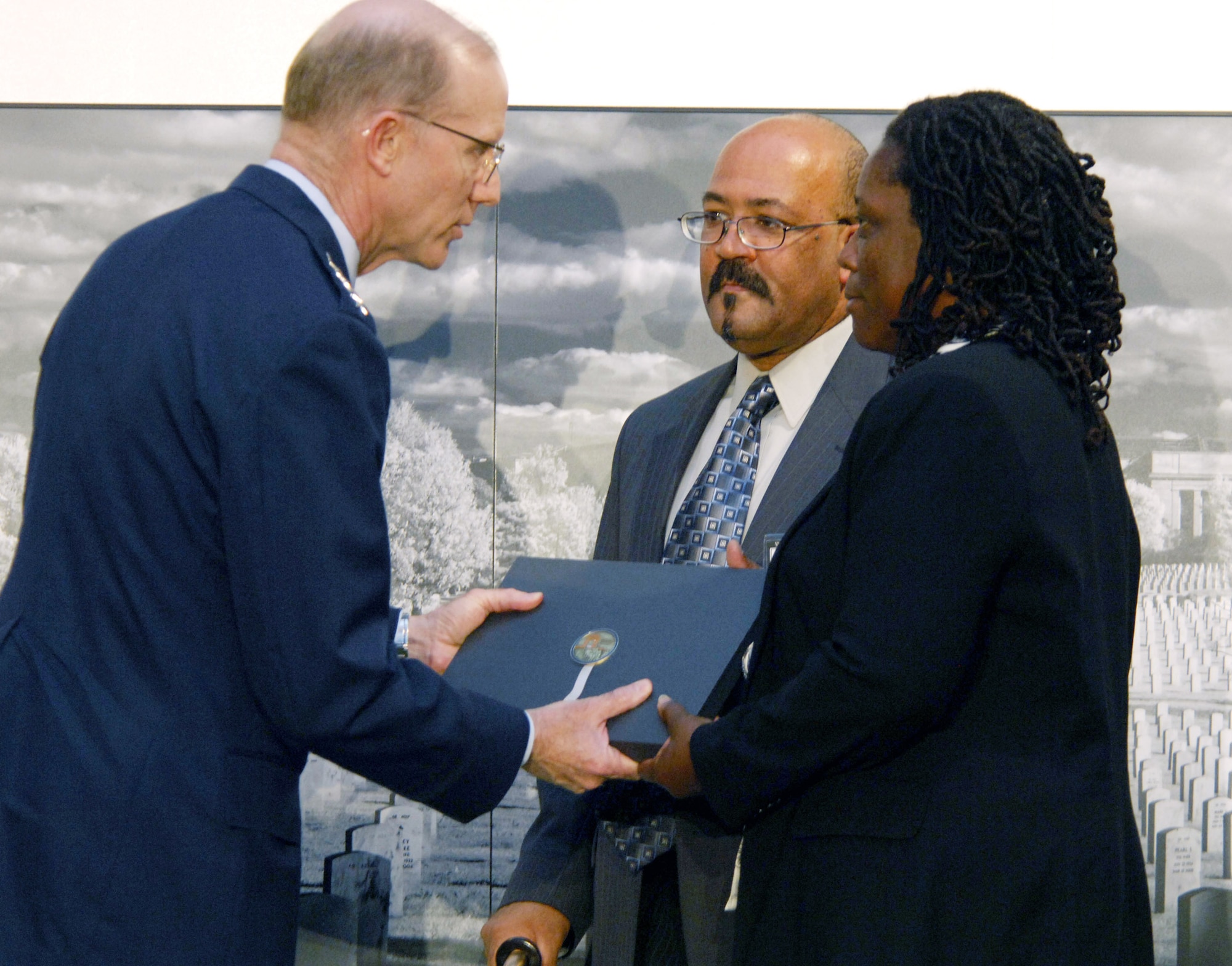 Air Force Vice Chief of Staff Gen. John D.W. Corley presents a commemorative photo book May 18 to Mike and Jacqueline Chavis, the parents of Airman 1st Class Lee Bernard Chavis, a security forces Airman who was killed in Iraq. The Chavis family represented the Air Force during a book presentation ceremony at Arlington National Cemetery, Va. The book has images from the many funerals that have occurred at Arlington during the fight against terrorism. There were five families at the ceremony who represented each of the service branches. (U.S. Air Force photo/Tech. Sgt. Cohen A. Young)