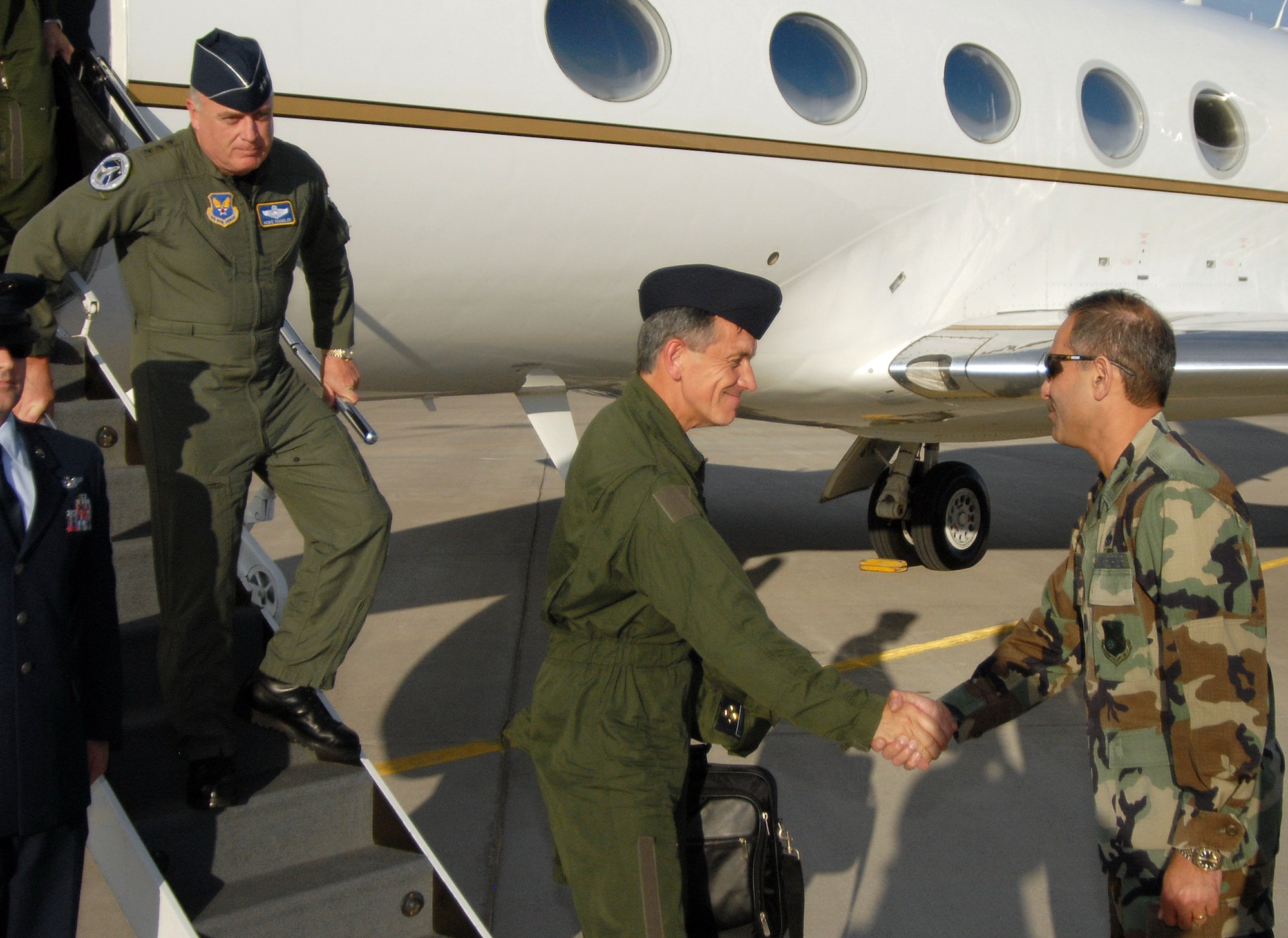 French Lt. Gen. Jean-Paul Palomeros, vice chief of staff of the French air force, shakes hands with Col. Mohsen Parhizkar, 377th Air Base Wing vice commander, upon the general?s arrival here. During his May 9-10 visit, the general toured the 58th Special Operations Wing with Lt. Gen. Howie Chandler, deputy chief of staff for Operations, Plans and Requirements, Headquarters U.S. Air Force, Washington, D.C., who is stepping off the plane.  U.S. Air Force photo by Laurence Zankowski