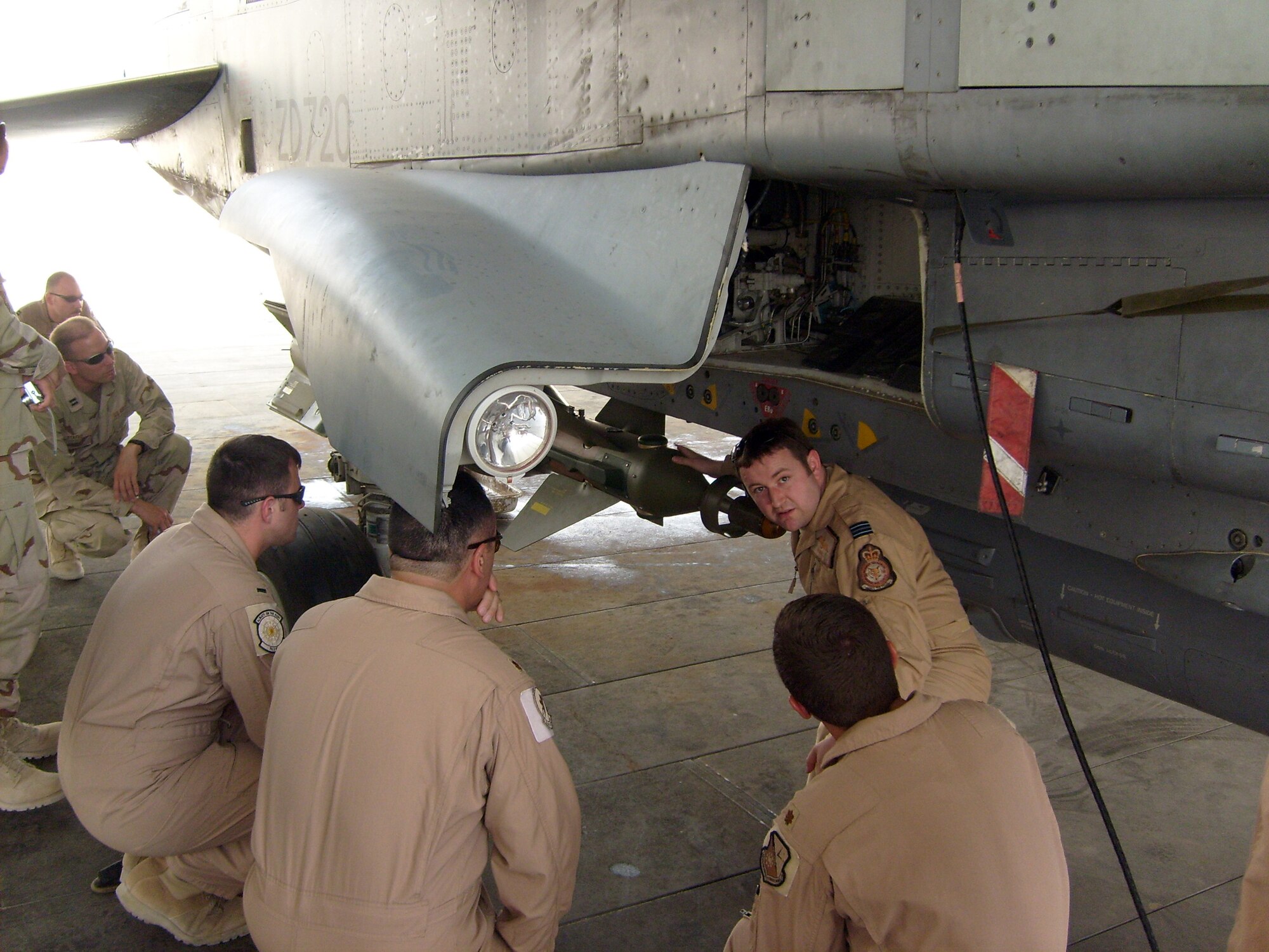 SOUTHWEST ASIA -- British Royal Air Force Flight Lieutenant Stuart Wallace, 901st Exeditionary Air Wing weapons system officer, explains the GR4 Tornado aircraft to personnel assigned to the 379th Air Expeditionary Wing. Every Friday the 379th Expeditionary Operations Support Squadron hosts the Mission Designated Series of the Week program to Airmen, Soldiers, Sailors, Marines and coalition partners in an effort to promote awareness of the aircraft deployed here and the roles they play in the Global War on Terrorism.
