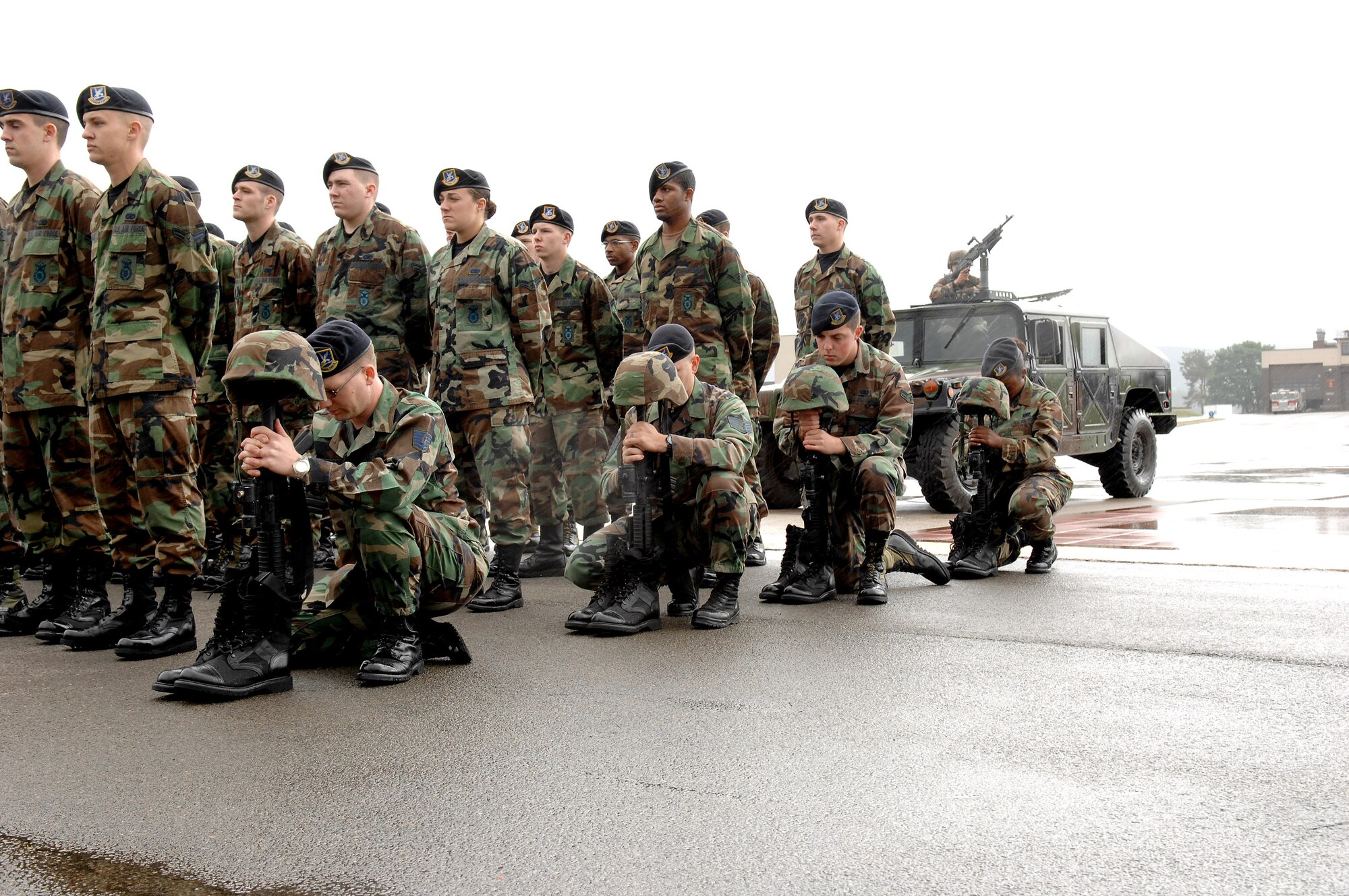 Tech. Sgt. Jason Moore (left to right), Staff Sgt. Robert Culbertson, Airman 1st Class Nathan Smith and Airman 1st Class Cheniel Martin kneel in place for fellow Airmen during the Last Guard Mount May 16 at Ramstein Air Base, Germany. The ceremony, which recognizes fallen security forces members, was held in conjunction with National Police Week. The Airmen are assigned to the 435th Security Forces Squadron. (U.S. Air Force photo/Senior Airman Levi Riendeau)
