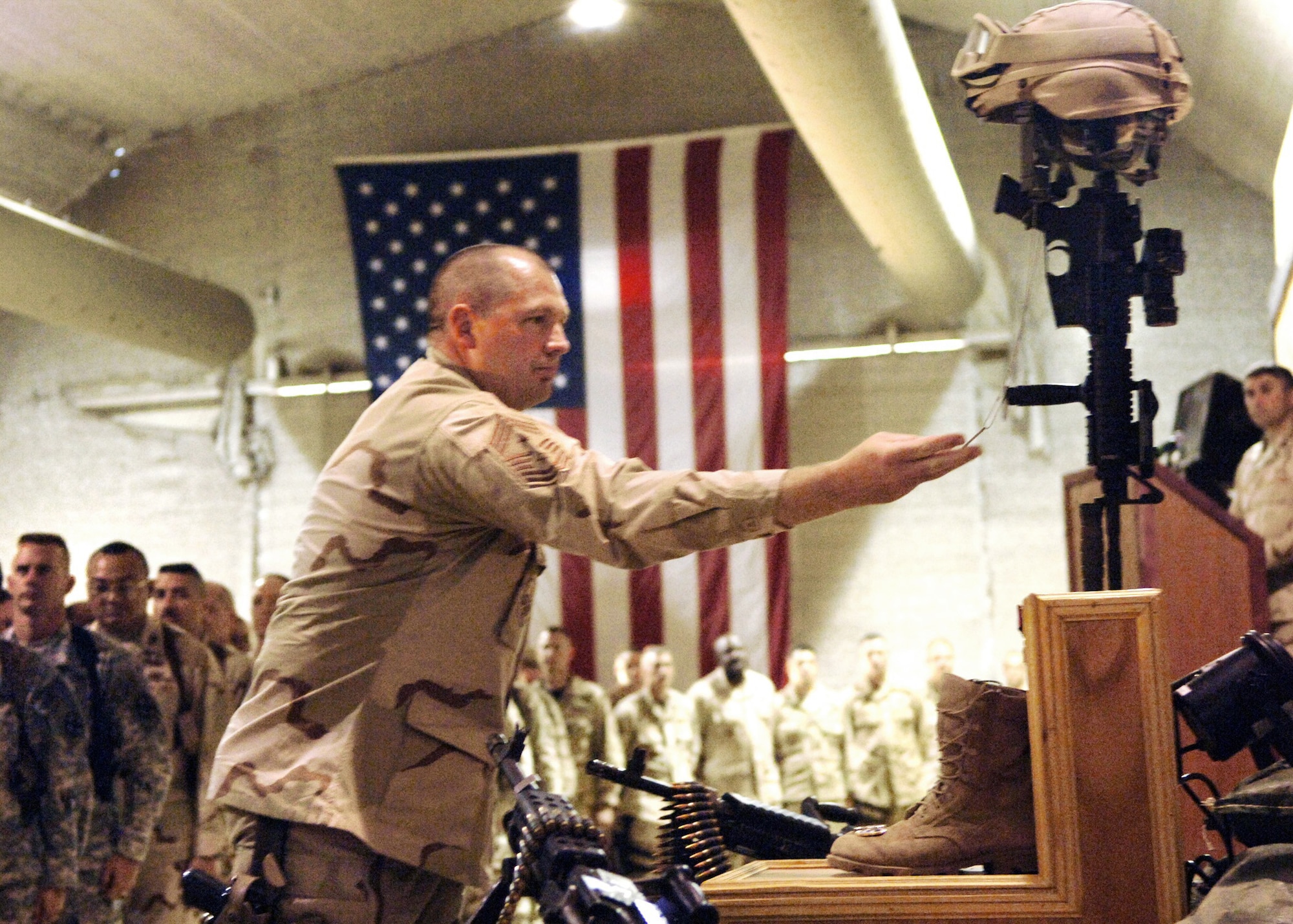 BALAD AIR BASE, Iraq - Chief Master Sgt. Scott Dearduff, 332nd Air Expeditionary Wing Command Chief Master Sergeant, holds Staff Sergeant John T. Self's dog tags to show respect during Staff Sgt. Self's memorial ceremony at the Balad Air Base Town Hall May 18, 2007.  Staff Sgt. Self, a Security Forces Defender assigned to Detachment 3, 732nd Expeditionary Security Forces Squadron, 732nd Air Expeditionary Group, 332nd Air Expeditionary Wing, died during combat operations May 14, 2007 near Baghdad, Iraq. (U.S. Air Force photo/Tech. Sgt. Alan Port)