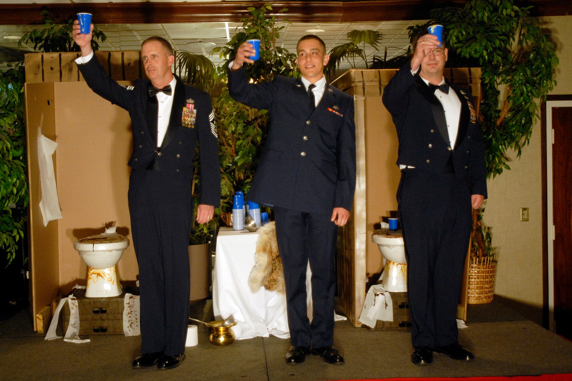 Chief Master Sgt. Timothy Omdal, 21st Space Wing command chief (left to right), Airman Antonio Jimenez, 21st Services Squadron, and Chief Master Sgt. Michael Sullivan, Air Force Space Command command chief, make a toast May 11 at the dining out. (U.S. Air Force photo by Larry Hulst)