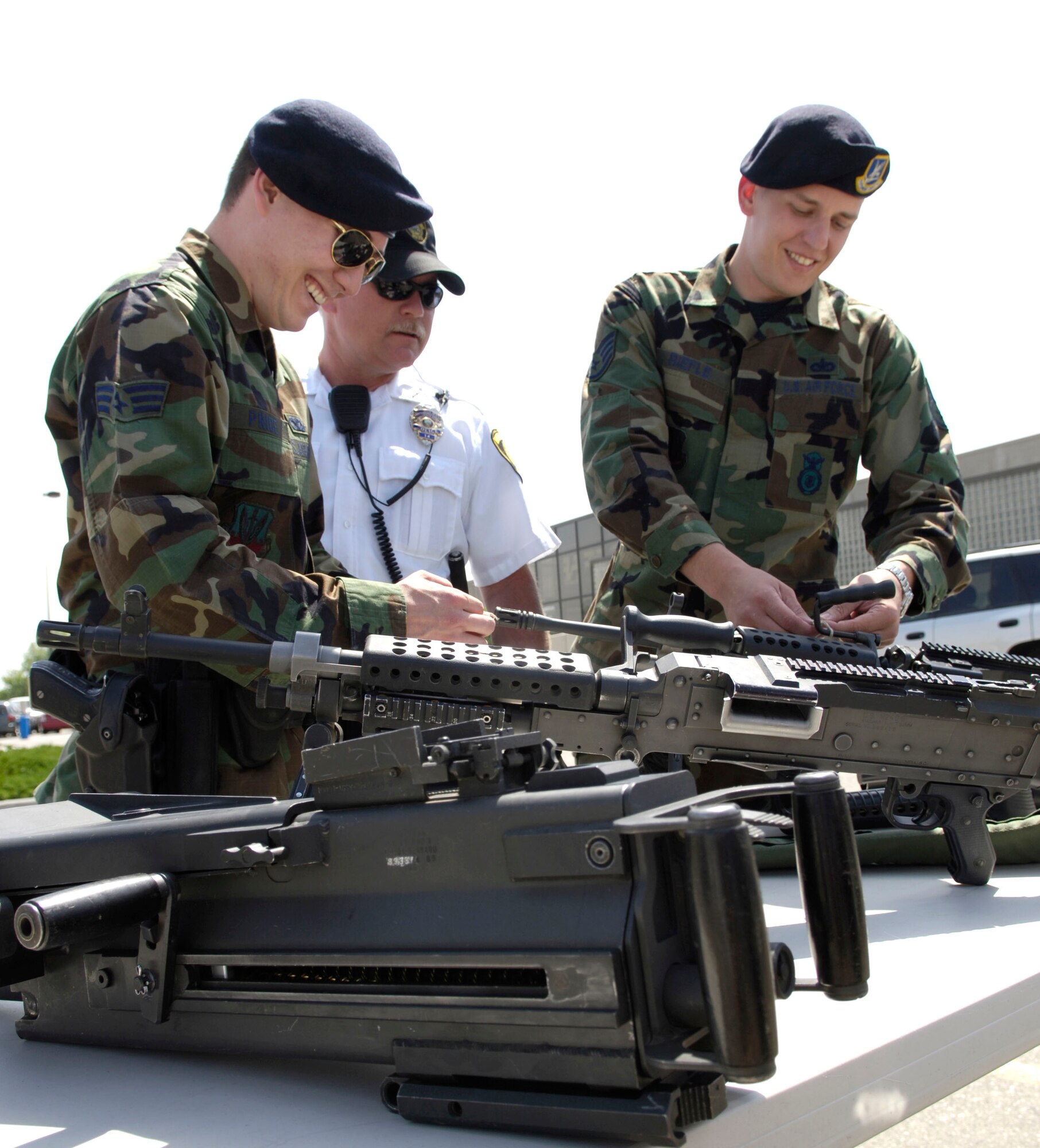 MOUNTAIN HOME AIR FORCE BASE, Idaho -- Senior Airman Thomas Price and Staff Sgt. Edward Riefel, both from the 366th Security Forces Squadron, assemble a .50-caliber machine gun while Patrolman Ron Wade from the Mountain Home Police Department looks on during a weapons display May 17 at the Base Exchange parking lot. The hands-on demonstration was one in a series of events planned during the base’s National Police Week observance. (U.S. Air Force photo/Airman First Class Ryan Crane)