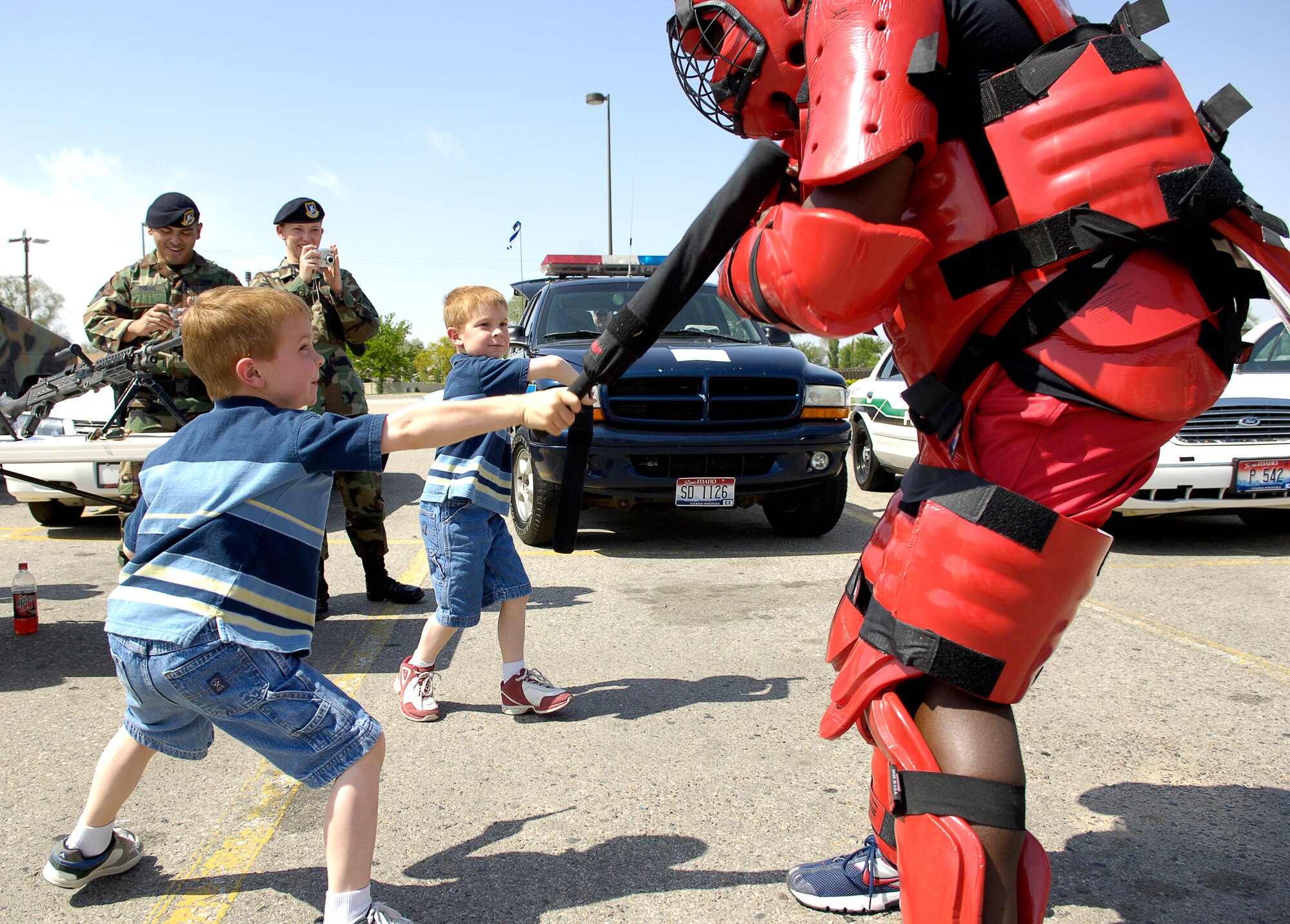 MOUNTAIN HOME AIR FORCE BASE, Idaho -- Sydney and Avery Phillips use padded batons to "subdue" Airman 1st Class Marquis Taylor from the 366th Security Forces Squadron during a security forces demonstration in the Base Exchange parking lot May 17. The interactive demonstrations were some of the many events scheduled during the base’s National Police Week observance. (U.S. Air Force photo/Airman First Class Ryan Crane)