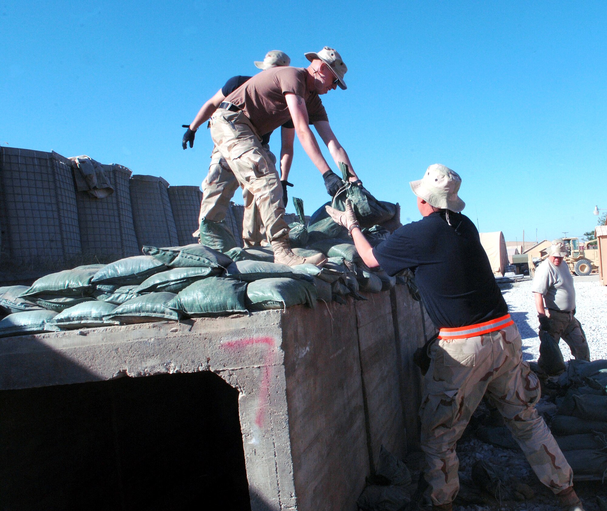Airmen from the 455th Air Expeditionary Wing remove sandbags in preparation for an upgrade to the deployed Airmen's living quarters on Camp Cunningham May 22 at Bagram Airfield, Afghanistan. The existing B-Huts the Airmen currently reside in will be relocated to this area to make way for sturdier relocatable buildings. The upgrade is currently scheduled to begin with eight B-Huts. (U.S. Air Force photo/Staff Sgt. Craig Seals)
