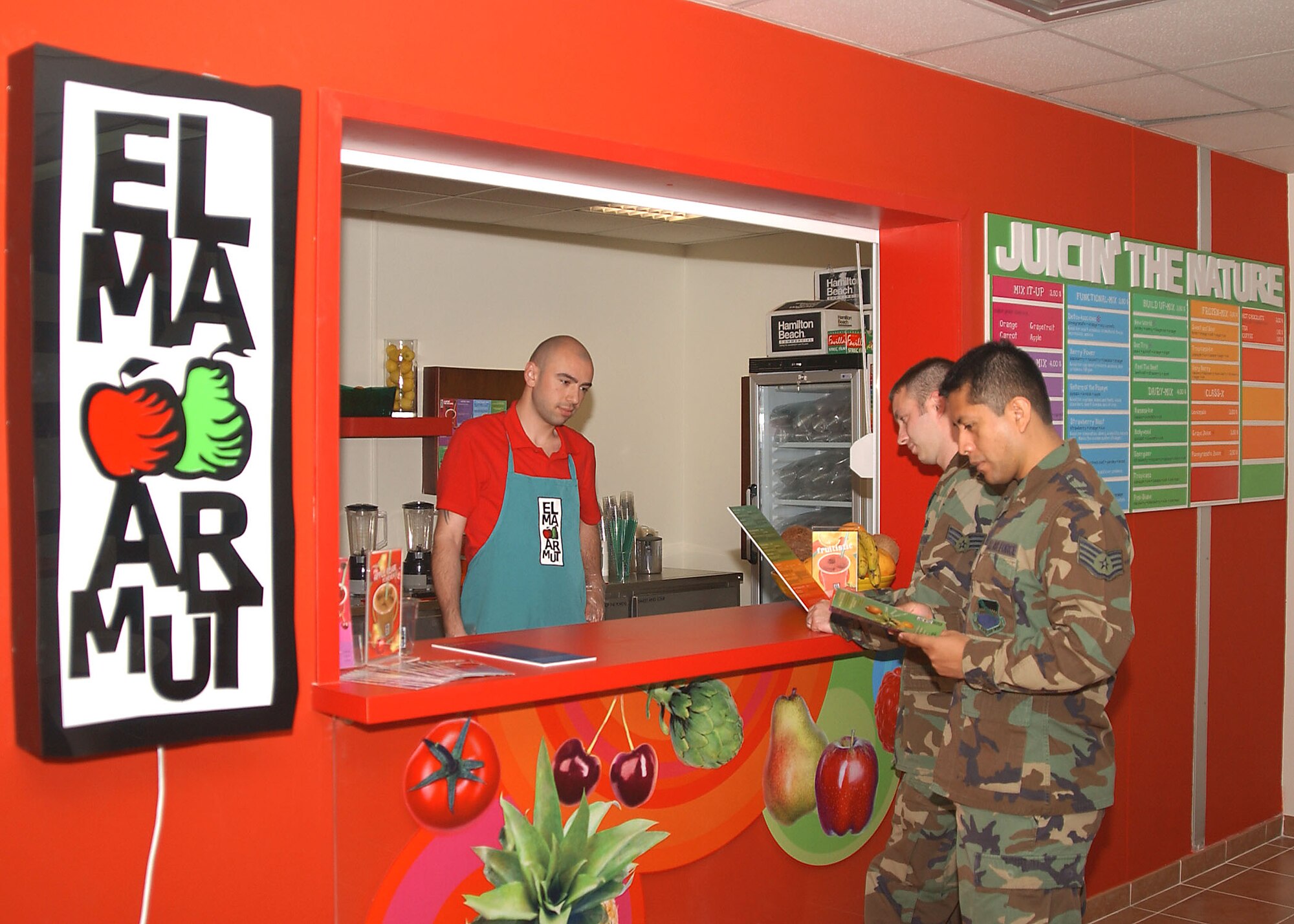 Staff Sgt. Jesus Mendoza and Senior Airman Byron Brown, 39th Services Squadron fitness center representatives, order a rejuvenating juice mixture from Alie Sertac Sandallioglu, Elma Armut employee, after a hard days work. (U.S. Air Force photo by Technical Sergeant Patrick Hyde)
