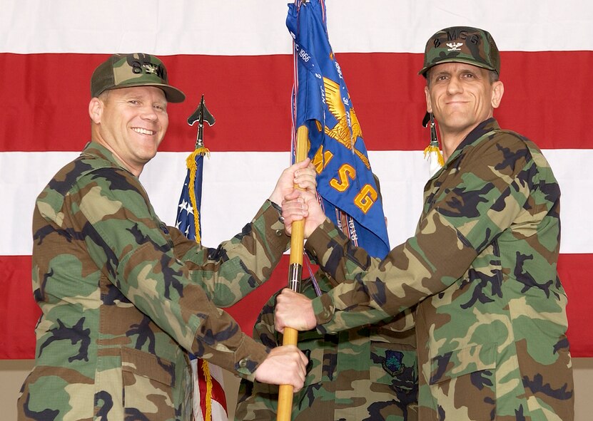 Colonel Jeffery Lofgren, 8 Fighter Wing Commander, hands the 8th Mission Support Group guidon to Col. Timothy Sakulich, new 8th MSG commander, during the change of command ceremony here May 22. Colonel Sakulich was last assigned as the director, programs and resources, Headquarters United States Southern Command, Miami, Fla. (U.S. Air Force photo/Staff Sergeant Darcie Ibidapo)