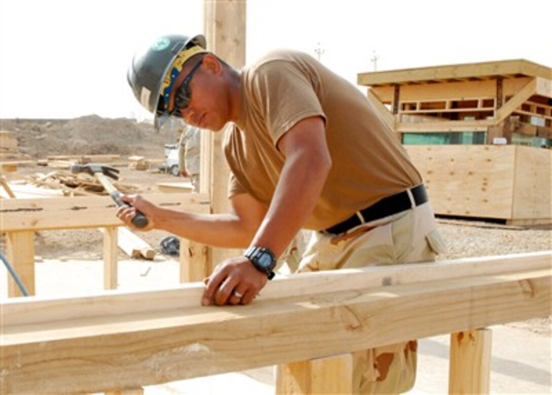 U.S. Navy Petty Officer 3rd Class Heranio Wagayen, of Naval Mobile Construction Battalion Four, constructs a building that will be used as a guard shack or billeting at Camp Ramadi, Iraq, on May 15, 2007.  