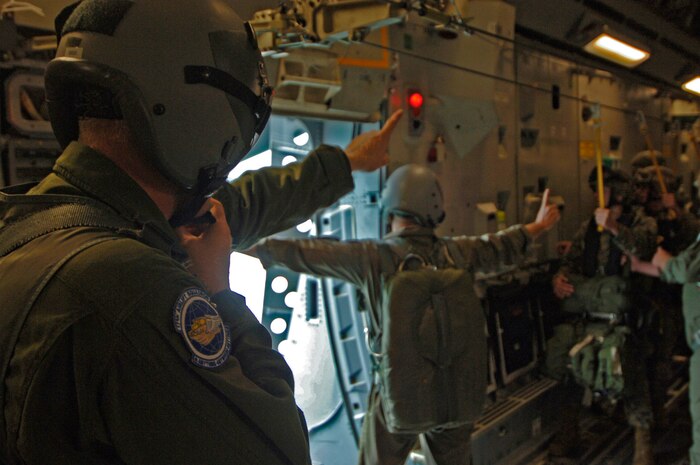 Staff Sgt. Brian Chaney, 17th Airlift Squadron loadmaster, informs Marine Sgt. Brian Trafton, 2nd Air Delivery jump master, and the Marines jumping that they have one minute until jump time May 18.  (U.S. Air Force photo/Staff Sgt. April Quintanilla)