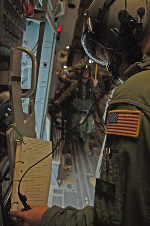Staff Sgt. Brain Chaney, 17 AS loadmaster, looks over the airdrop standard procedures as he and the Marines wait for the jump time to approach.  (U.S. Air Force photo/Staff Sgt. April Quintanilla)