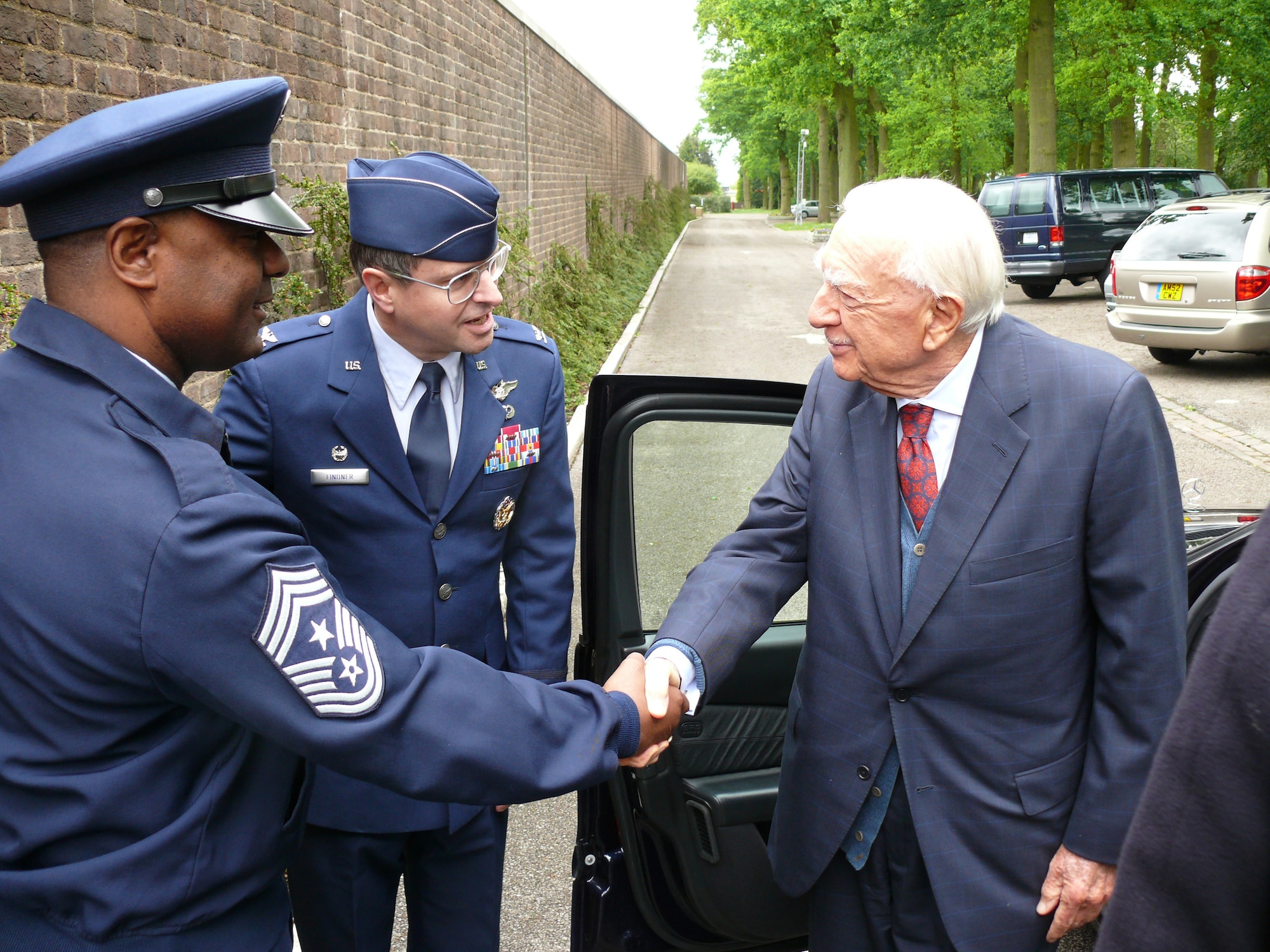 Chief Master Sgt. Robert Dandridge shakes hands with Walter Cronkite May 23 at the Cambridge American Cemetery in the United Kingdom as Col. Blake Lindner looks on. Mr. Cronkite came to the cemetery to tape a piece for an upcoming PBS special, which covers his time in the U.K. during the war. Chief Dandridge is the command chief and Colonel Lindner is the commander of the 501st Combat Support Wing. (U.S. Air Force photo/Tech. Sgt. Scott Wakefield)