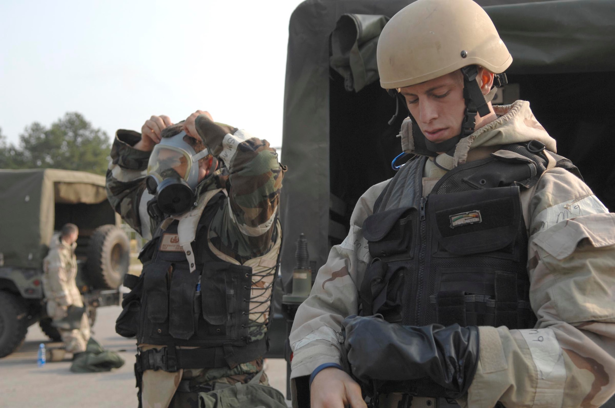 SHAW AIR FORCE BASE, S.C. -- Airman 1st Class Trevor Brown (right) and Senior Airman Eric Charlton, both 20th Civil Engineer Squadron Explosive Ordinance Disposal bomb technicians, secure their chemical gear before a Mission Oriented Protective Posture Level 4 driving course while participating in a field training exercise May 23. As part of the four-day FTX the 20th CES trained in self-aid buddy care, cardiopulmonary resuscitation, weapons safety, decontamination, security, land navigation, night operations and any job-specific training required. (U.S. Air Force photo by Airman First Class Kathrine McDowell)