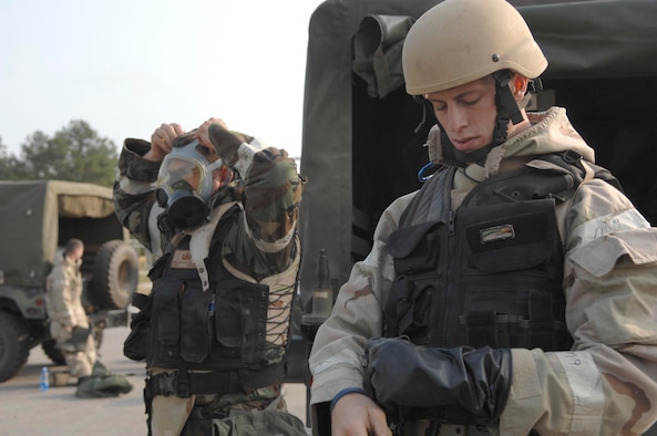 SHAW AIR FORCE BASE, S.C. -- Airman 1st Class Trevor Brown (right) and Senior Airman Eric Charlton, both 20th Civil Engineer Squadron Explosive Ordinance Disposal bomb technicians, secure their chemical gear before a Mission Oriented Protective Posture Level 4 driving course while participating in a field training exercise May 23. As part of the four-day FTX the 20th CES trained in self-aid buddy care, cardiopulmonary resuscitation, weapons safety, decontamination, security, land navigation, night operations and any job-specific training required. (U.S. Air Force photo by Airman First Class Kathrine McDowell)