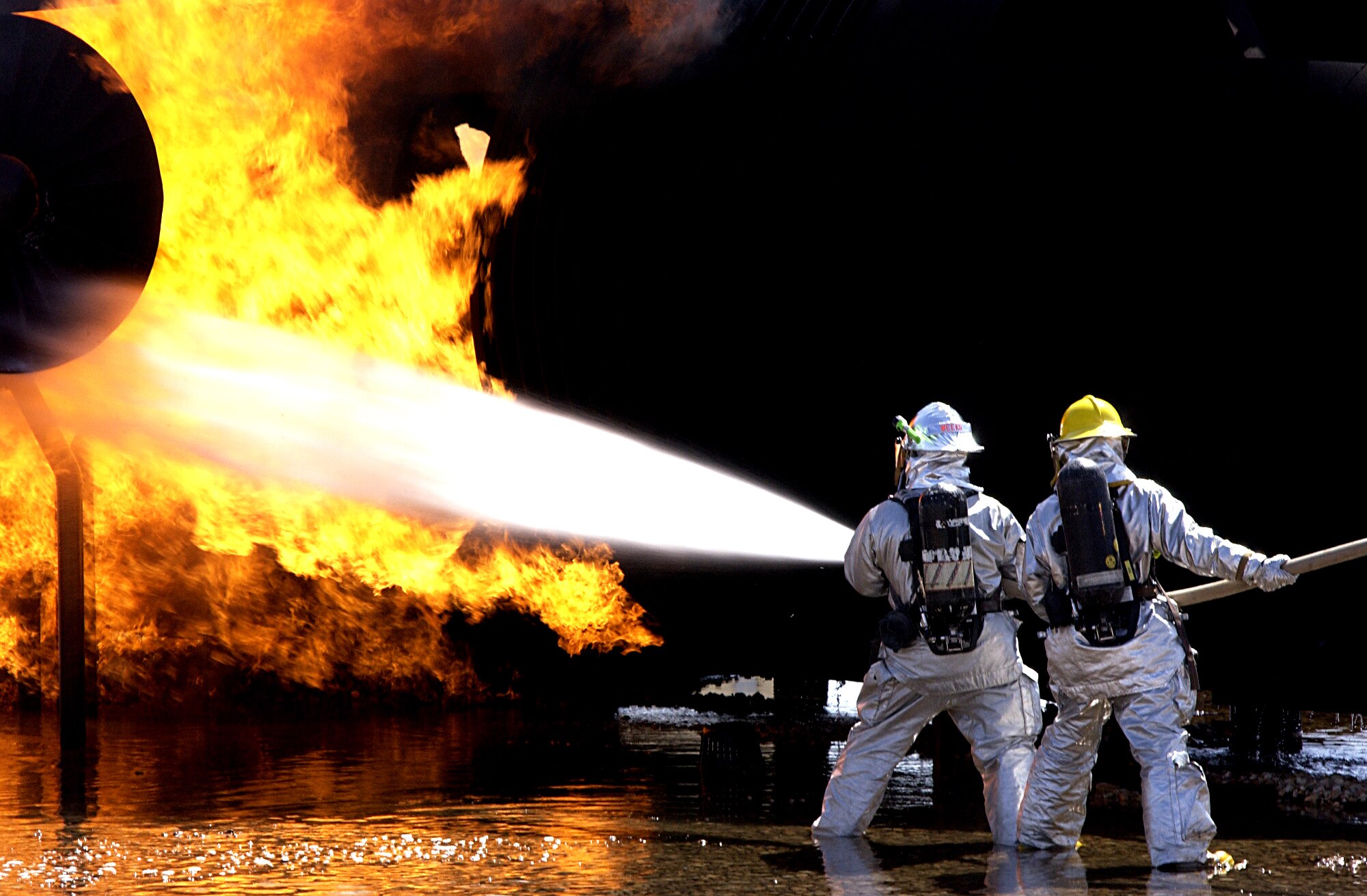 Firefighters from the 99th Civil Engineering Squadron and Clark County McCarran International Airport simulate fighting an aircraft fire in a joint training program here May 17, 2007.  This is the third time Nellis Firefighters have trained with Clark County in a joint exercise (U.S. Air Force photo/Airman 1st Class Ryan Whitney). 