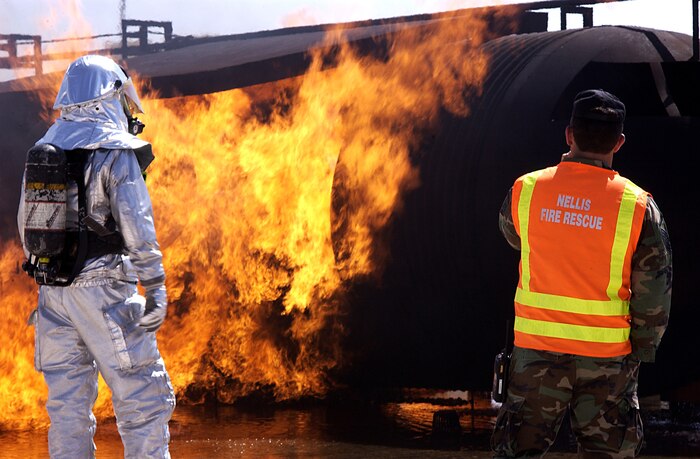 Master Sgt. James Giddens, 99 Civil Engineers Squadron Firefighter, radios to the control tower and lets them know the team is ready to engage the fire.  The control tower controls the flames by increasing or decreasing the amount of propane that is fed to the flames (U.S. Air Force  photo/ Airman 1st Class Ryan Whitney)