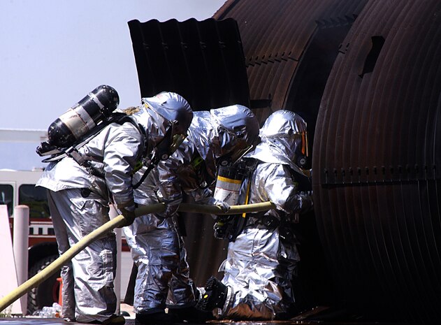 Firefighters from the 99th Civil Engineer Squadron and Clark County McCarran International Airport practice entry procedures to combat fire on the interior of an aircraft May 17, 2007.  Although the fires in this event are controlled, it helps prepare firefighter's for the worst case scenario (U.S. Air Force photo/Airman 1st Class Ryan Whitney).                                
