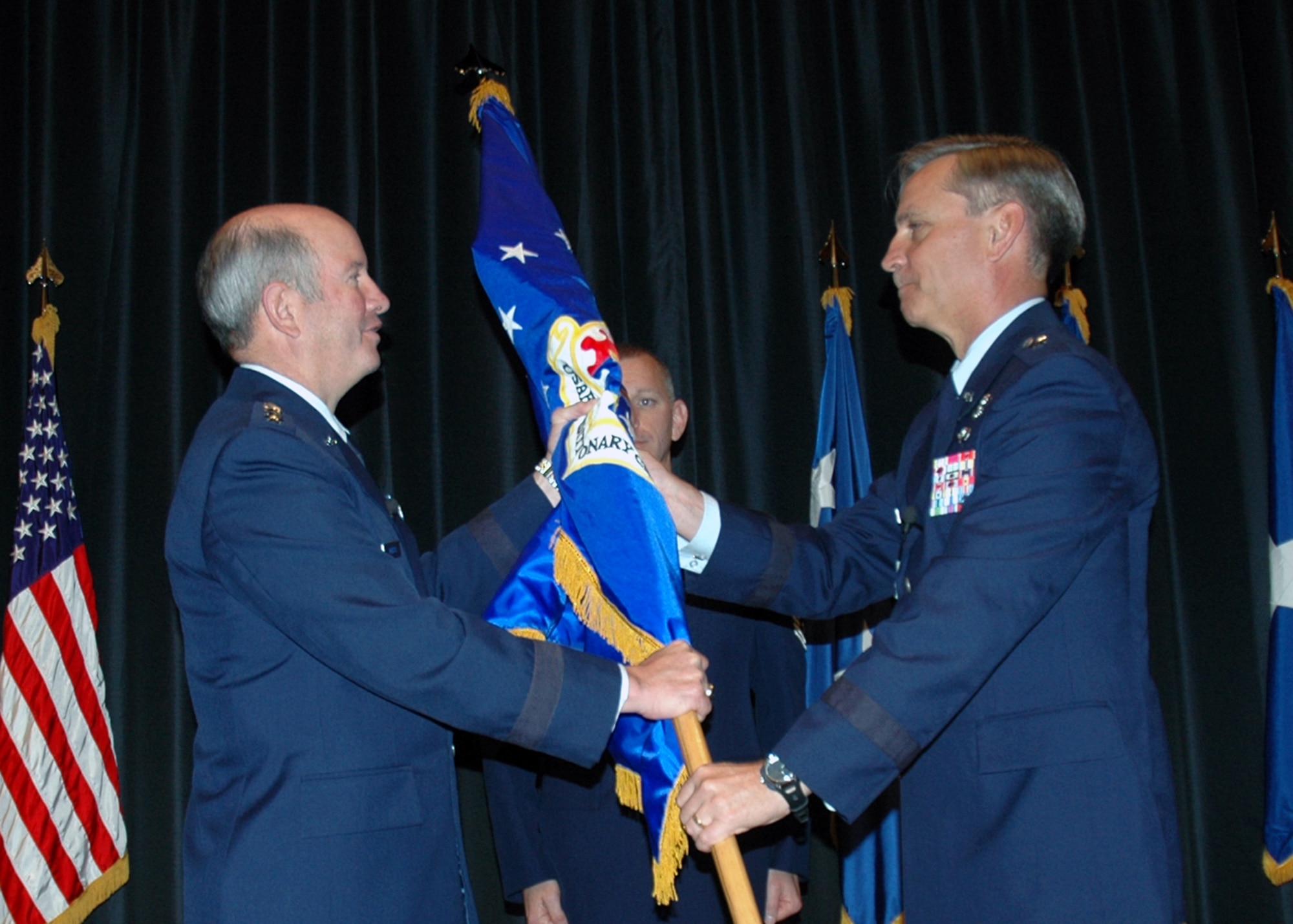 U.S. Air Force Gen. Duncan McNabb, commander of Air Mobility Command, hands the flag and leadership of the U.S. Air Force Expeditionary Center to Brig. Gen. Kip Self during a change of command ceremony May 23, 2007, at the Center on Fort Dix, N.J.  (U.S. Air Force Photo/Tech. Sgt. Malinda Julian)