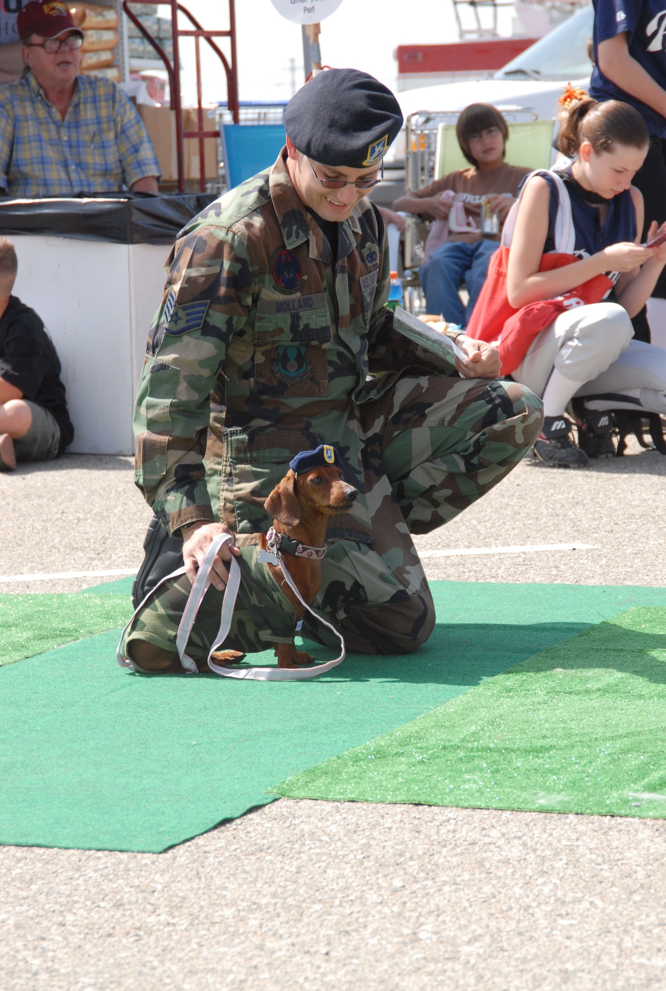 Staff Sgt. Francis Mollard III, 95th Security Forces Squadron trainer, shows his 5-year-old miniature dachschund, Slinky, for a look-a-like contest during the third annual Bark in the Parking Lot at the Base Exchange on May 19. (Photo by Airman Mike Young)