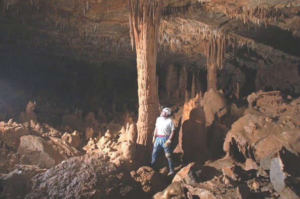 Arnold Engineering Development Center's Brian Roebuck stands next to a column of limestone in a large chamber in Cedar Ridge Crystal Cave near South Pittsburg, Tenn. The photograph was taken by his wife Lynn, an avid nature photographer and active member of the local chapter of the National Speleological Society. Roebuck and his wife had a cave millipede named after them for their assistance in cave conservation and species identification. It is called millipede genus P. roebuckorum. (Photo by Lynn Roebuck)
