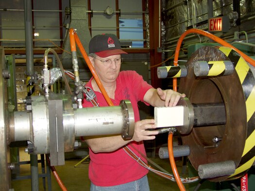 Machinist Larry Phipps at the Air Force’s Arnold Engineering Development Center loads a foam projectile into an 86-foot-long rectangular barrel used to conduct impact testing for the Space Shuttle Return to Flight program.