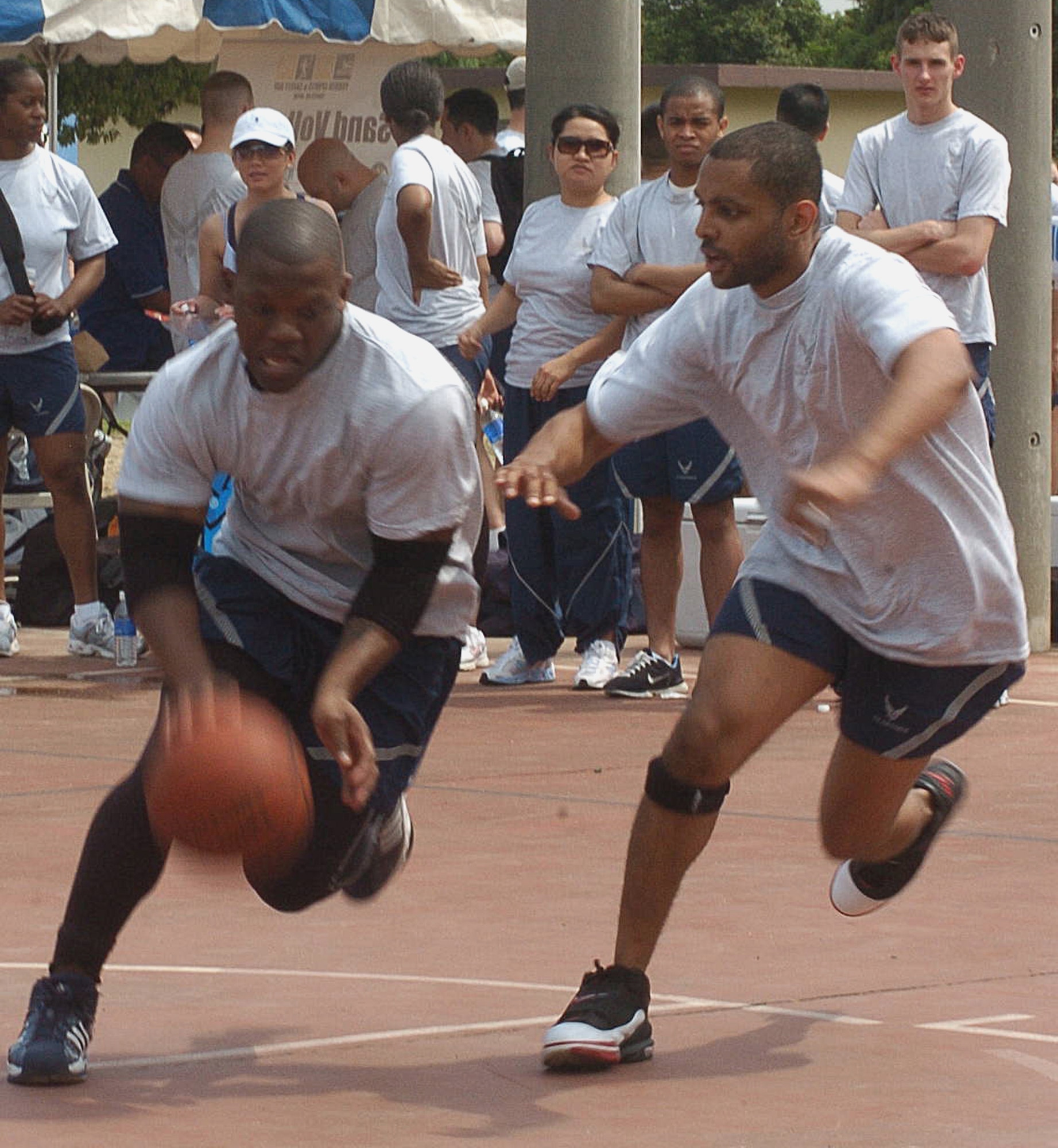 Senior Airman Will Anderson from the 374 Maintenance Squadron and Staff Sergeant Antonio Mack from the 374 Services Squadron play basketball as a part of the base-wide Sports Day. (U.S. Air Force photo by Airman Leandra Hernandez VIRIN 070518-F-8186H)
