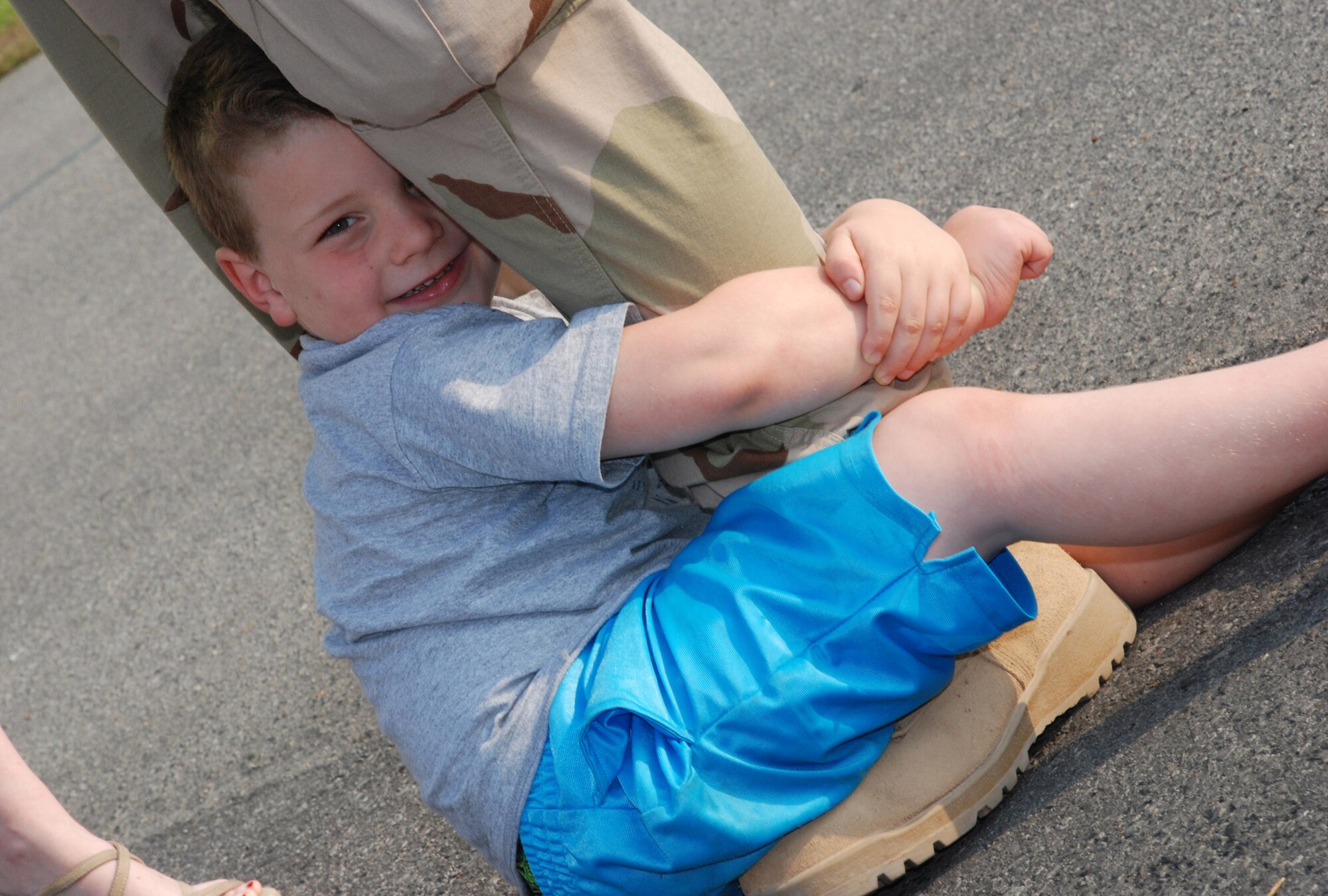 Damian Reandeau, 5, latches on to Staff Sgt. Thomas Duggan's leg during the homecoming celebration May 24 at Eglin Air Force Base, Fla. Family members gathered at Eglin AFB to welcome home more than 175 members of the 728th Air Control Squadron from a deployment in support of Operation Iraqi Freedom. (U.S. Air Force photo by Staff Sgt. Mike Meares) 