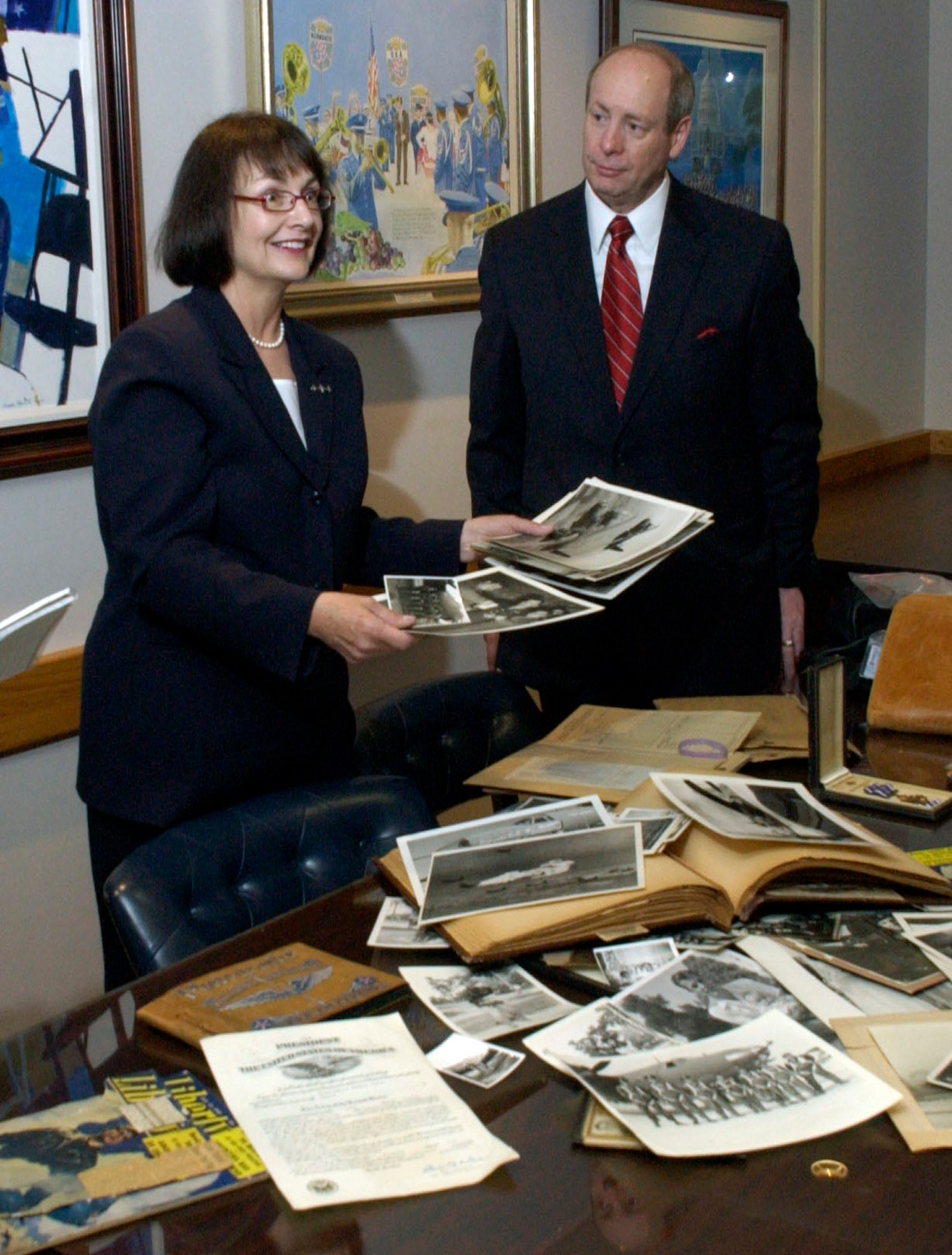Carol and Bruce Ready look through her father's military service memorabilia. They visited the U.S. Air Force Band building, historic Hangar II, May 21 at Bolling Air Force Base, Washington, D.C. to view a portrait of her father, Capt. Thomas Wakeman. The portrait was painted in 1944. Captain Wakeman was a World War II veteran and B-26 Marauder pilot for the Army Air Forces. (U.S. Air Force photo/Tech. Sgt. Cohen A. Young)