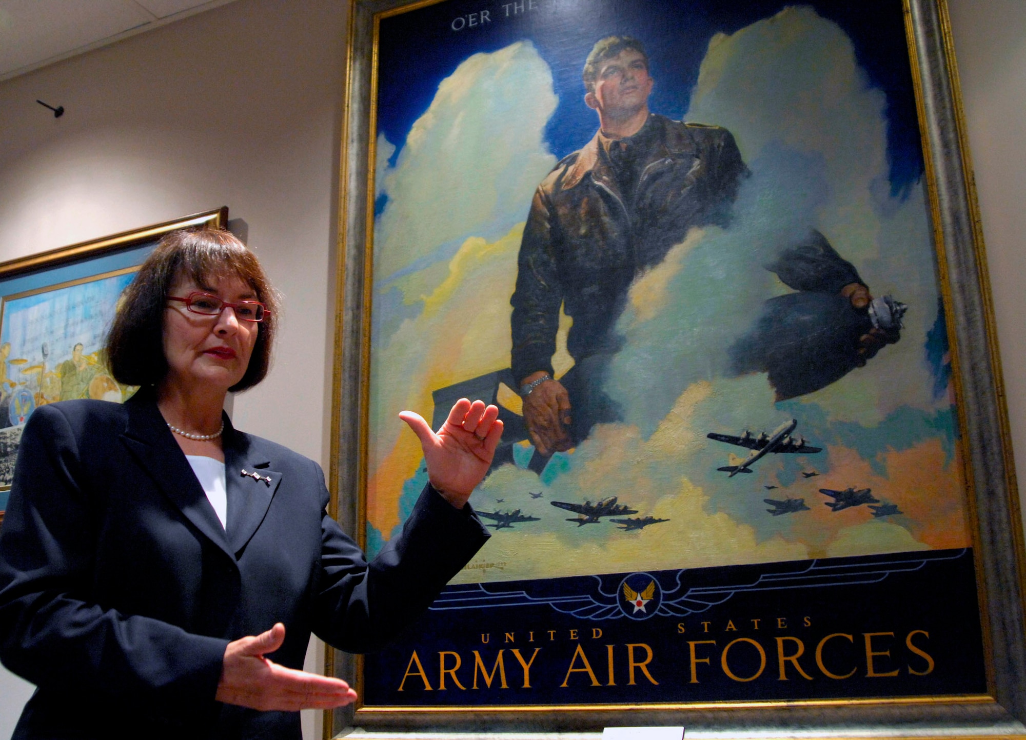 Carol Ready stands next to a portrait of her father, Capt. Thomas Wakeman May 21 at Bolling Air Force Base, Washington, D.C. Captain Wakeman was a World War II veteran and B-26 Marauder pilot. For the first time, Mrs. Ready saw the original portrait, which was painted in 1944. It is on display at the U.S. Air Force Band Headquarters building. (U.S. Air Force photo/Tech. Sgt. Cohen A. Young)