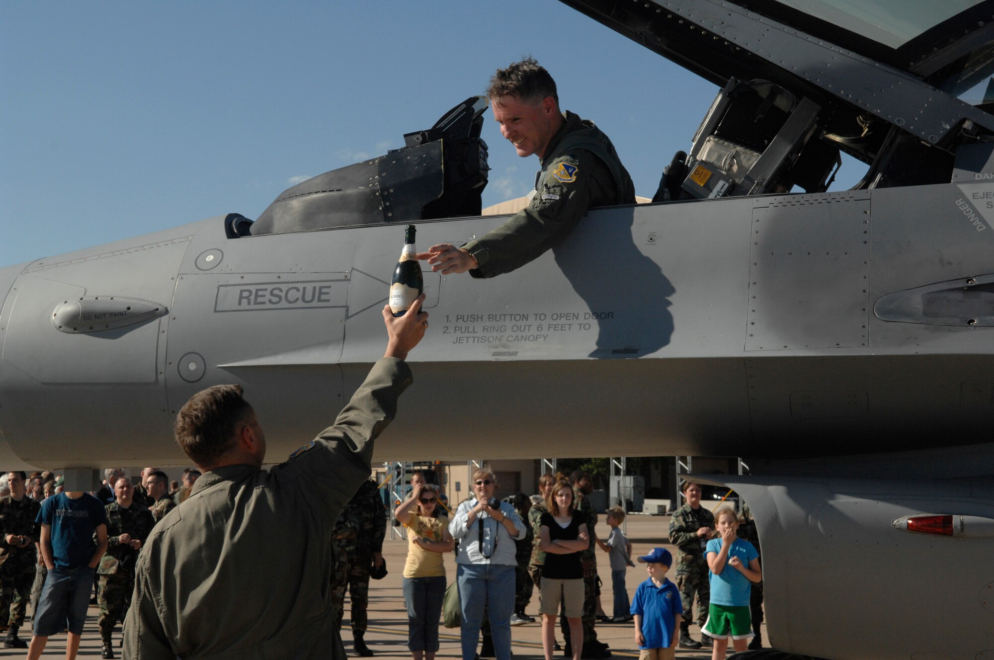 CANNON AIR FORCE BASE, N.M. -- Lt. Col. Brad Kearney, 523rd Fighter Squadron commander, is handed a traditional bottle of champagne from Col. Scott West, 27th Fighter Wing commander, following the squadron's final flight May 10. The "Crusaders" squadron inactivated May 23 after more than 60 years of service. (U.S. Air Force photo by Airman Erik Cardenas)