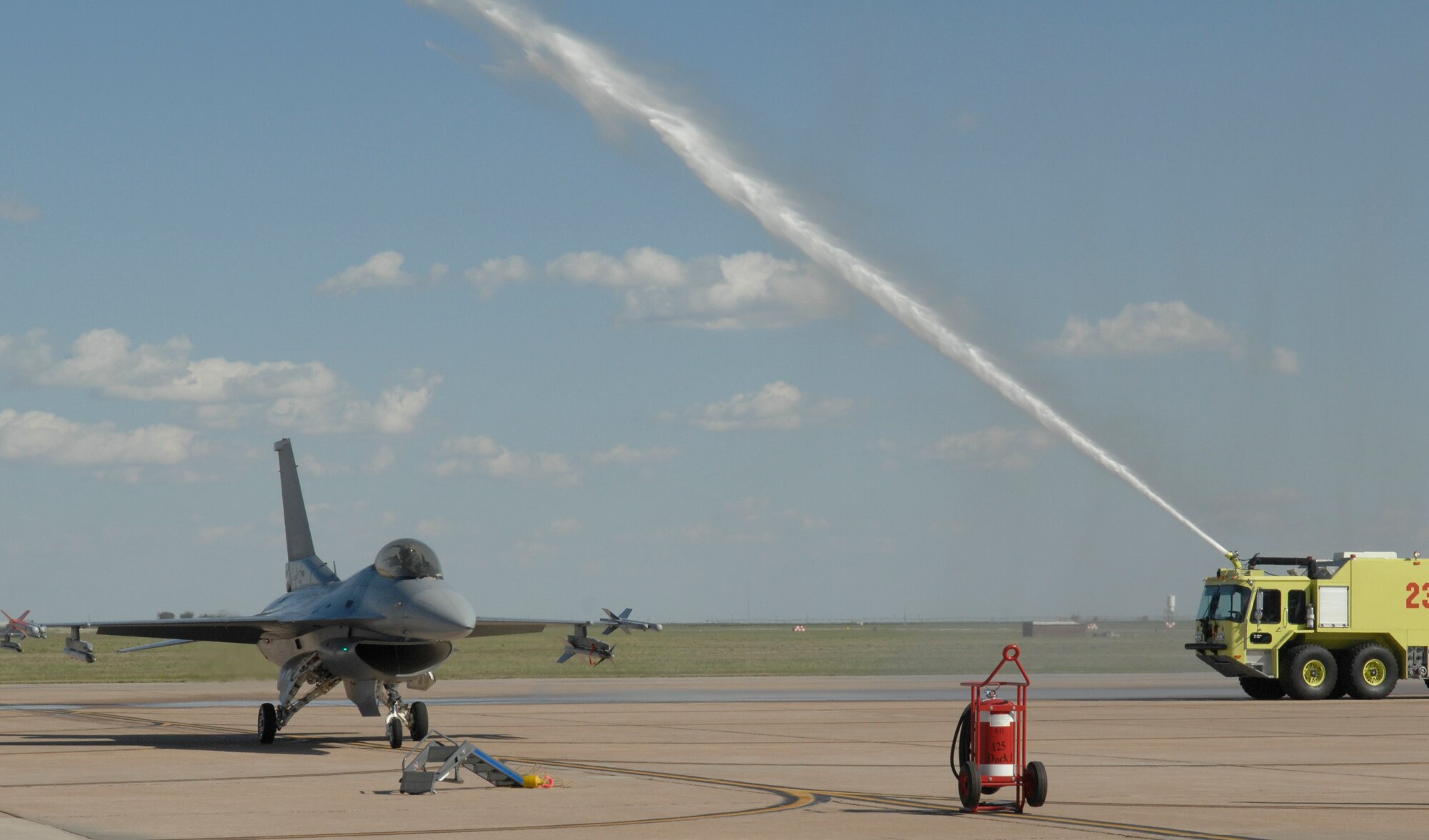 CANNON AIR FORCE BASE, N.M. -- A firetruck hoses down an F-16 piloted by Lt. Col. Brad Kearney, 523rd Fighter Squadron commander, on May 10 following the final flight of the squadron. The squadron inactivated on May 23. (U.S. Air Force photo by Airman Erik Cardenas)