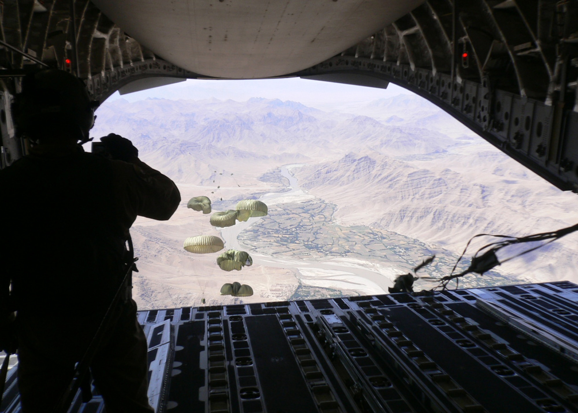 Staff Sgt. Derek Howard, 816th Expeditionary Airlift Squadron, watches six Container Delivery System supply bundles as they parachute to the ground over Afghanistan May 24.  The C-17 employed the Joint Precision Airdrop System in combination with the Improved Container Delivery System to increase accuracy of airdrops.  The I-CDS airdrops provide resupply to forward operating locations in Afghanistan supporting Operation Enduring Freedom. (U.S. Air Force Photo/Tech. Sgt. Gary Kleinfeldt)