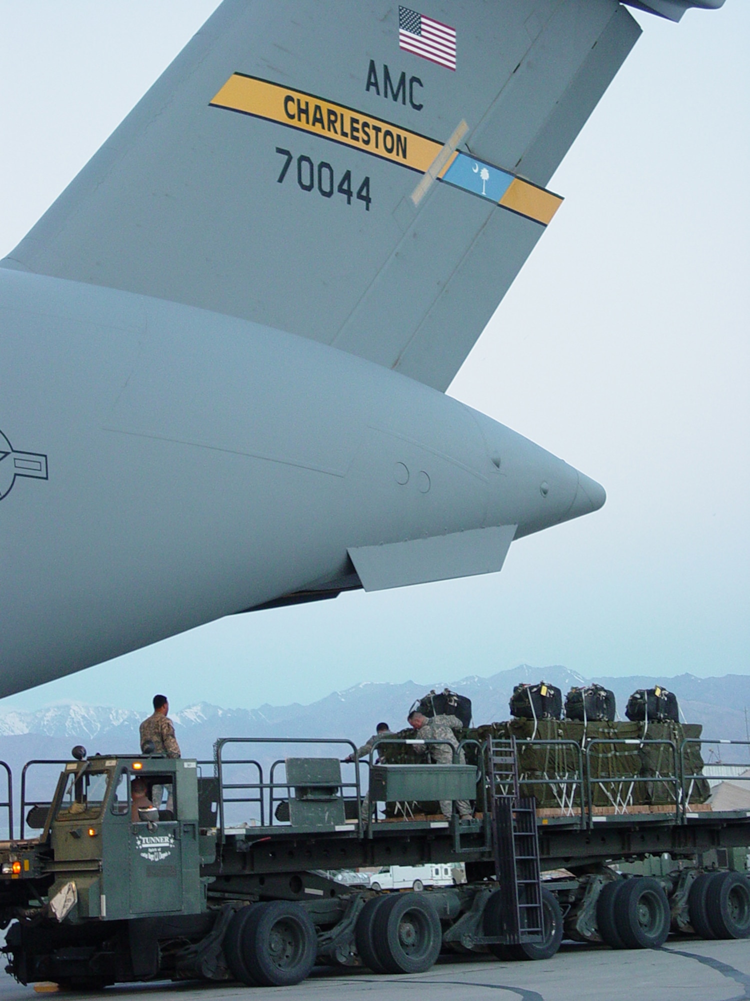 A C-17A Globemaster III from Charleston Air Force Base, S.C. is being loaded with Container Delivery System bundles prior to an airdrop mission over Afghanistan on May 24.  The mission marked the first C-17 combat employment of the Joint Precision Airdrop System in conjunction with the Screamer Container Delivery System bundles. (U.S. Air Force Photo/Capt. Jeffrey Liegl)