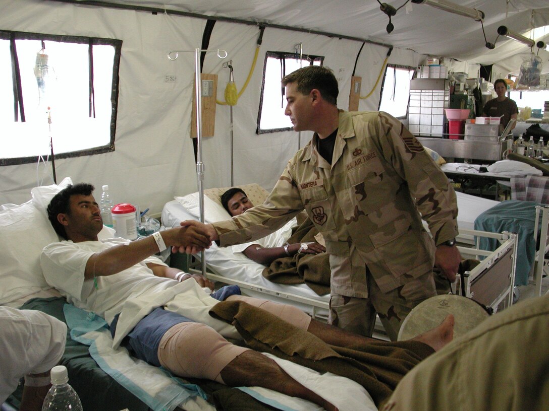 Master Sergeant Doug Montera takes time to shake hands with an injured Iraqi policeman after an impromptu performance at the American hospital in Ballad, Iraq.  Sergeant Montera is the Noncommissioned Officer-In-Charge of Night Wing, the popular music group from the USAF Heartland of America Band that deployed to the desert in 2006.