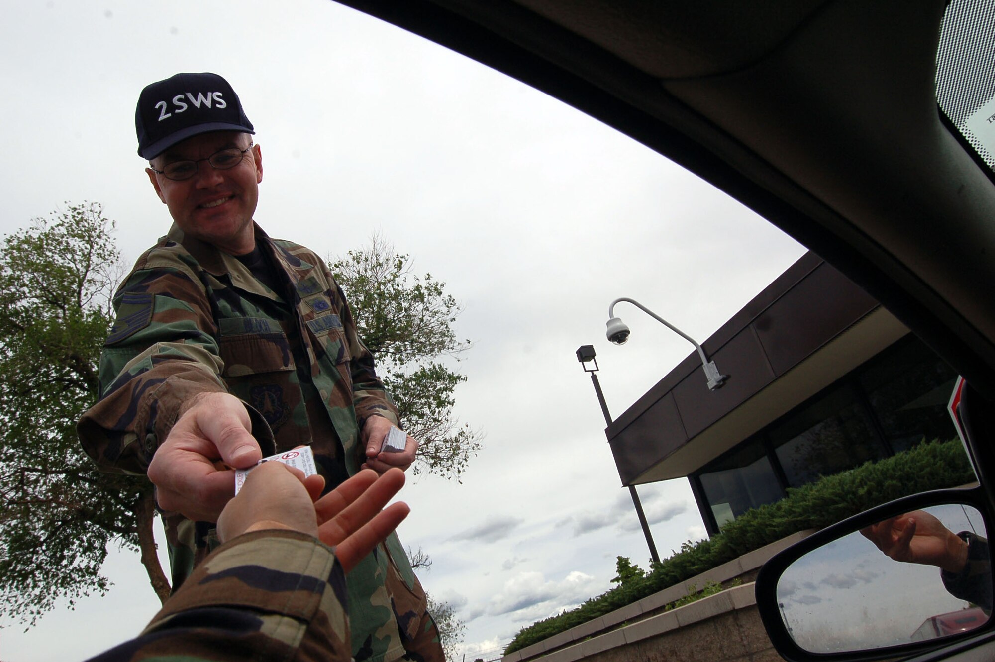 Senior Master Sgt. Michael Bloch, from the 2nd Space Warning System, hands a card to a Buckley member driving through the main gate May 24. He and other 460th Operations Group members handed out the cards to remind Buckley members about safe habits for the Memorial Day weekend and the kickoff of 101 Critical Days of Summer.