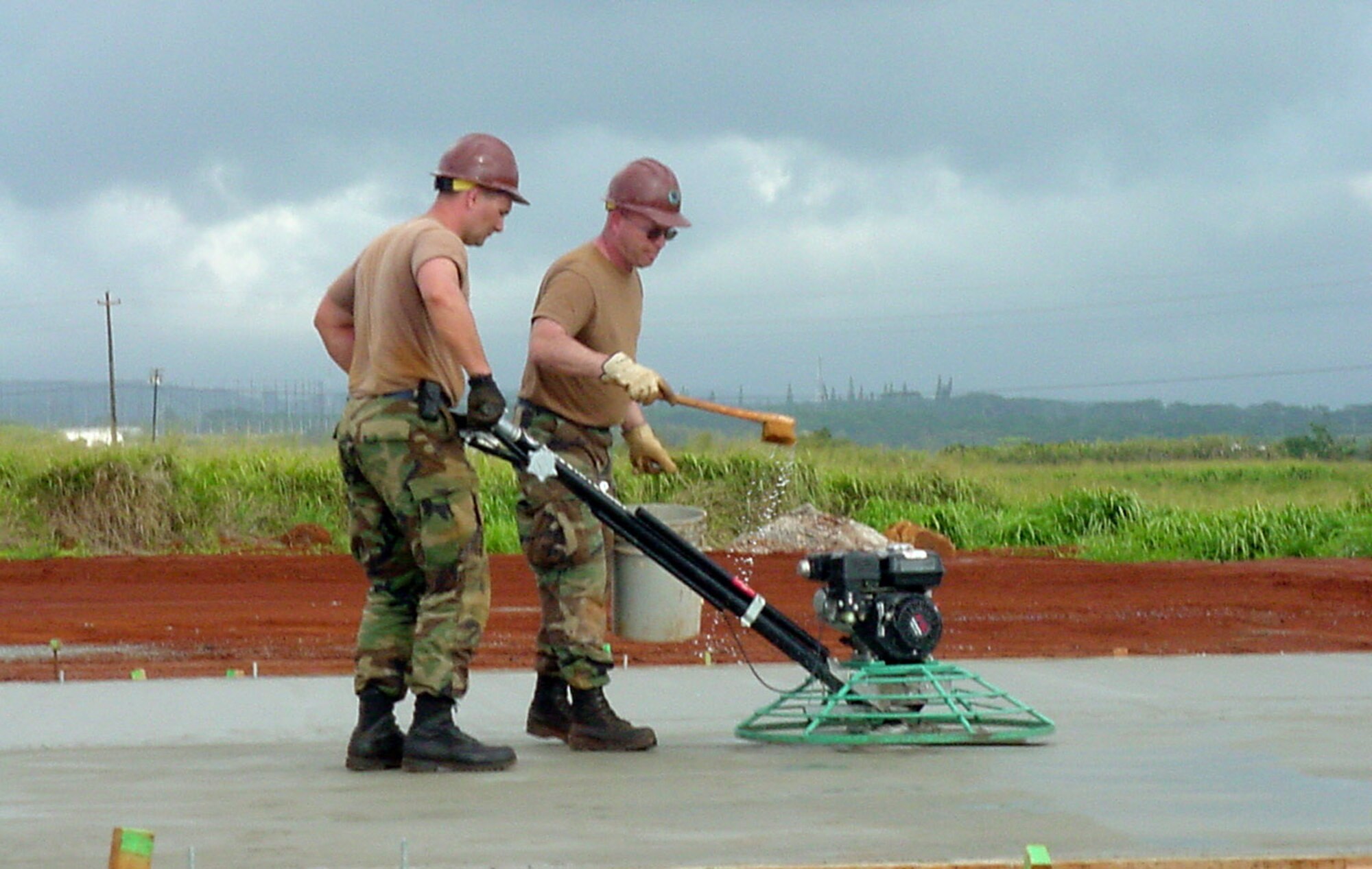 Tech. Sgt. Ryan Arnold smoothes concrete while Senior Master Sgt. Gregory Karrels sprinkles water over the worked area. Both civil engineers are assigned to the 440th Airlift Wing based at General Mitchell Air Reserve Station in Milwaukee. Forty-four reservists from the 440th Civil Engineer Squadron deployed on the humanitarian mission to Hawaii. (U.S. Air Force photo/Maj. Gwen Sheppard) 
