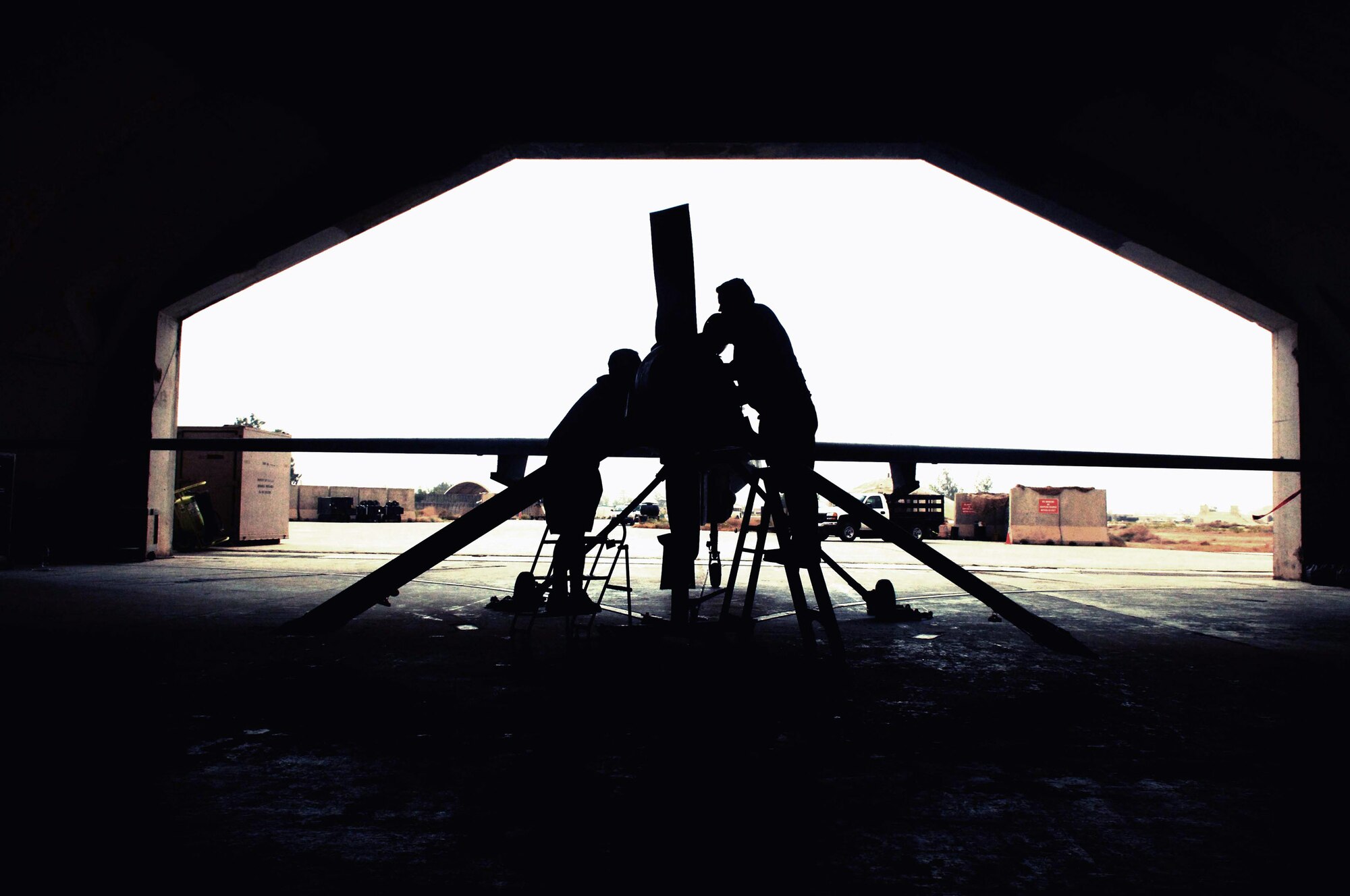 Avionics mechanics Jonathan Hagy and Russell Gordy work on an MQ-1 Predator unmanned aerial vehicle May 17 at Balad Air Base, Iraq.  The Predator provides armed reconnaissance, airborne surveillance and target acquisition for Iraq. (U.S. Air Force photo/Airman 1st Class Jonathan Steffen)