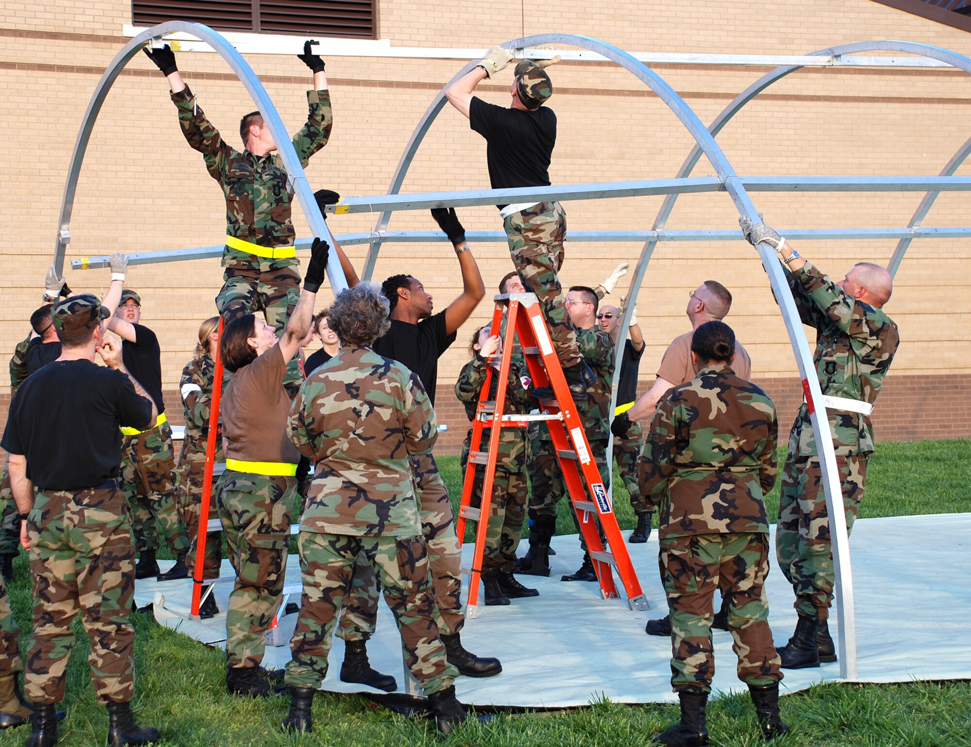 The Medical Group works together to build portable structure called an Alaskan shelter during Medical Unit Readiness Training at the clinic May 18. An Alaskan structure serves as a hospital in a deployed environment. (Photo by Airman 1st Class Jessica Lockoski)