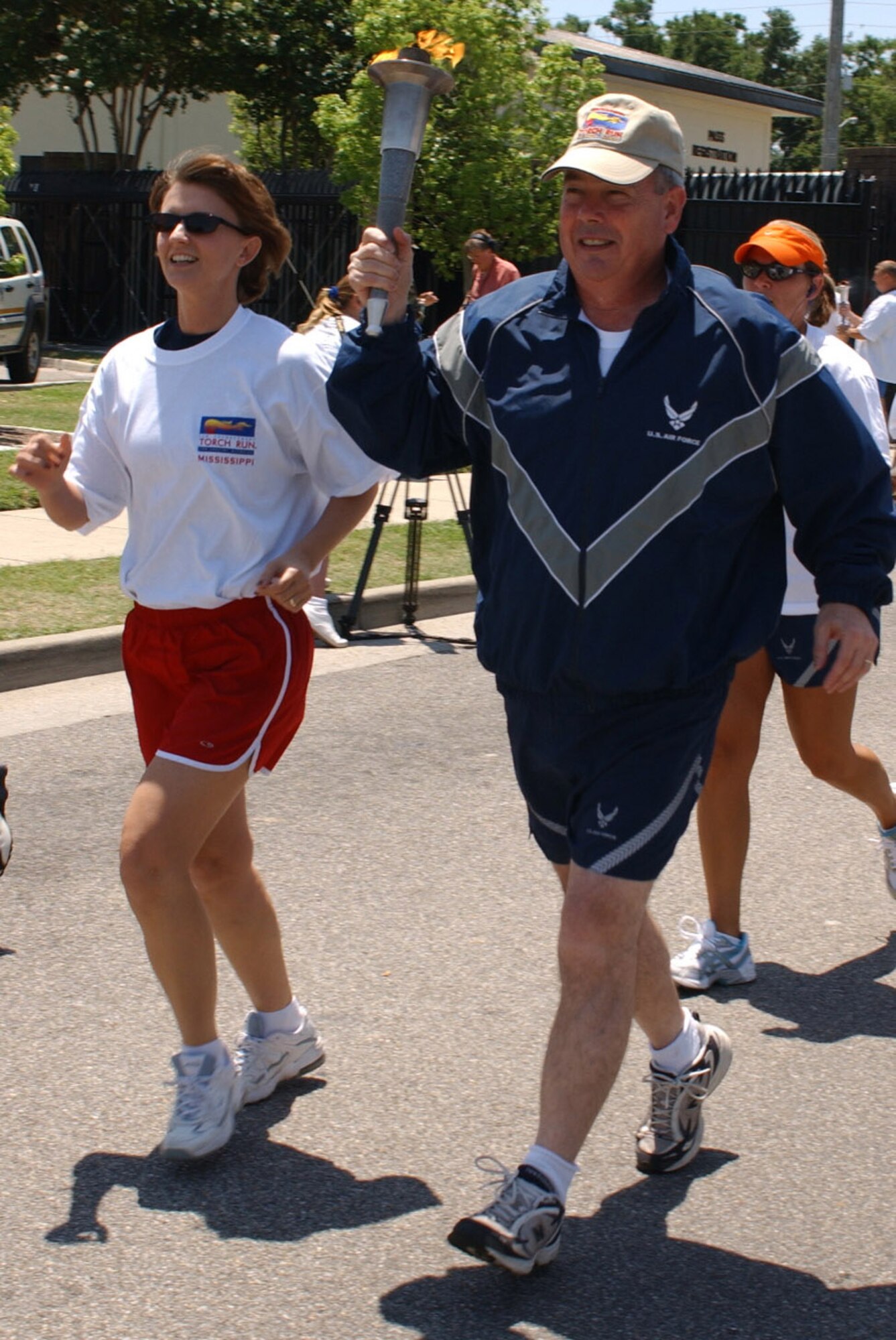 Paul Capasso, 81st Training Wing commander, with wife Laura alongside, accepted the torch from 81st Security Forces Squadron members at the White Avenue Gate Friday.  The 81st SFS members, along with Biloxi police, ran the torch to Keesler’s gate as part of the Special Olympics Law Enforcement Torch Run.   (U. S. Air Force Photo by Kemberly Groue)