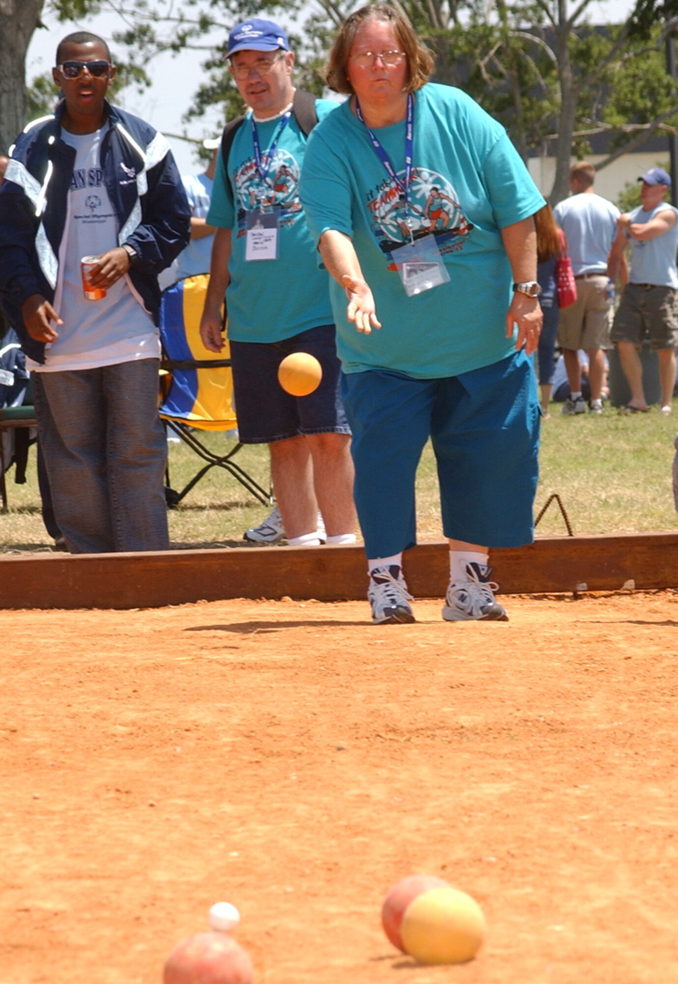 Donna Tillman, Area 12, throws a bocce ball Saturday at the Triangle Track as an Airman sponsor looks on.  Each athlete was assigned two Airman sponsors to bunk with and escort them throughout the weekend. (U. S. Air Force Photo by Kemberly Groue)