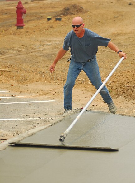 MOODY AIR FORCE BASE, Ga, --  Gary Lamb, 23rd Civil Engineer Squadron, uses a float to level fresh concrete in a new sidewalk in front of Moody’s new Consolidated Base Support Center May 22. The $9.6 million facility is scheduled to be completed this summer. (U.S. Air Force photo by Tech. Sgt. Parker Gyokeres)