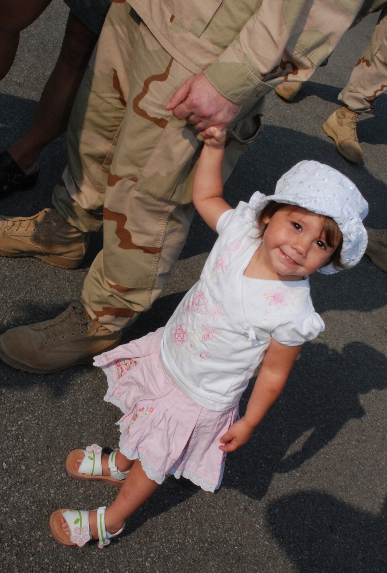 EGLIN AIR FORCE BASE, Fla. -- Ryleigh Edwards, 2, holds the hand of her grandfather, Capt. George Sanderlin, after reuniting with him May 24 at the homecoming celebration for the 728th Air Control Squadron. Family members gathered in front of the squadron as more than 175 members of the 728th ACS, the Demons, returned home from a deployment to Southwest Asia in support of Operation Iraqi Freedom. The 728th ACS mission encompasses the widest variety of Air Force careers, affording it global reach and the ability to complete its mission anywhere needed. The Airmen spent the last five months in Iraq controlling and monitoring Iraqi airspace, assisting in providing close air support for troops in conflict and reconnaissance and directing tanker traffic for refueling efforts. The squadron has spent nine of the past 12 months deployed. (U.S. Air Force photo by Staff Sgt. Mike Meares)