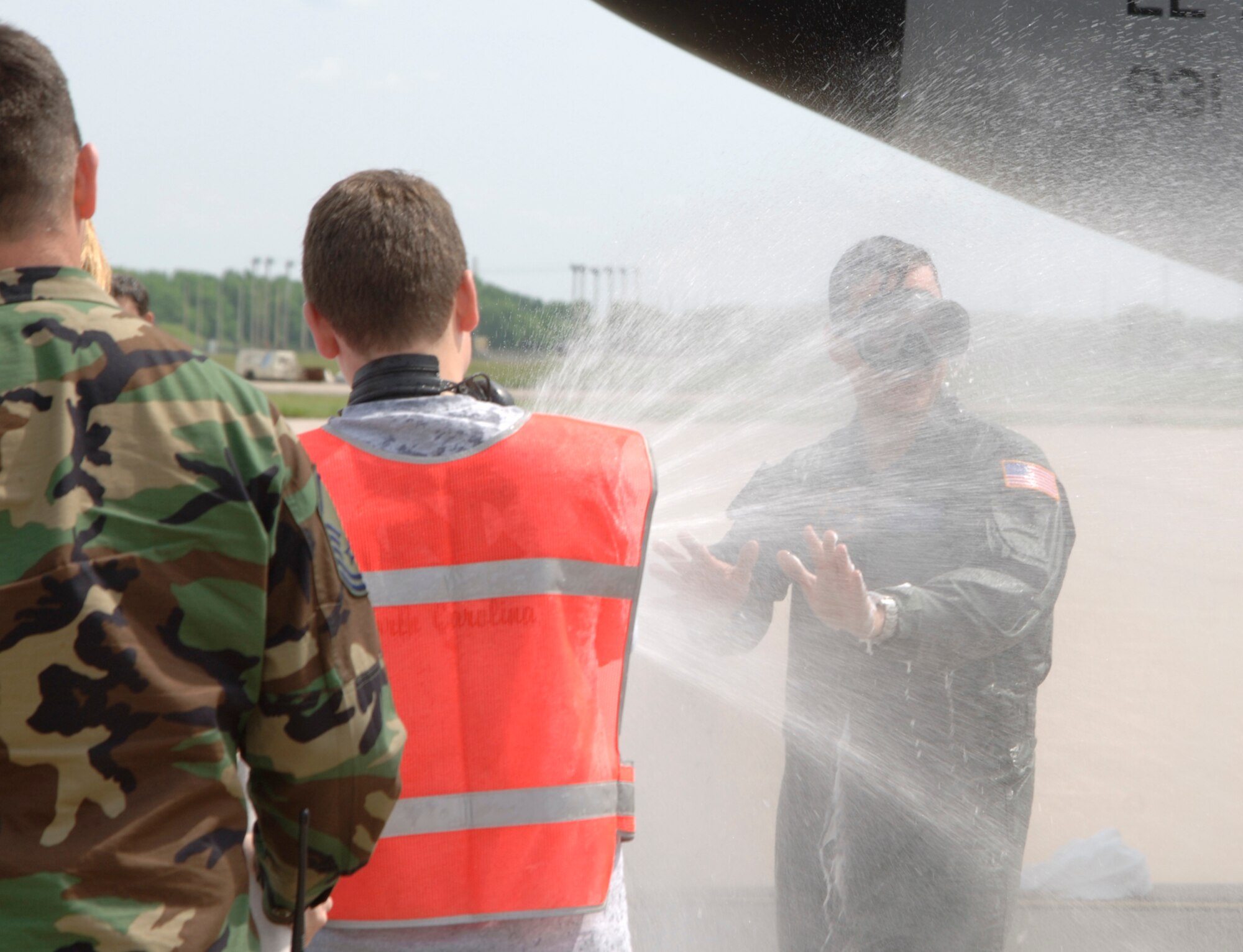 Forrest Smith, 15, sprays his father, Col. T. Harrison Smith, Jr., 22nd Air Refueling Wing vice commander, with water from a fire hose to celebrate Col. Smith’s final flight at McConnell. During his 23 years of service, he spent more than one year at McConnell and will serve his next assignment as commander of the 376th Air Expeditionary Wing, Manas Air Force Base, Kyrgyzstan. (Photo by Airman 1st Class Jamie Train)