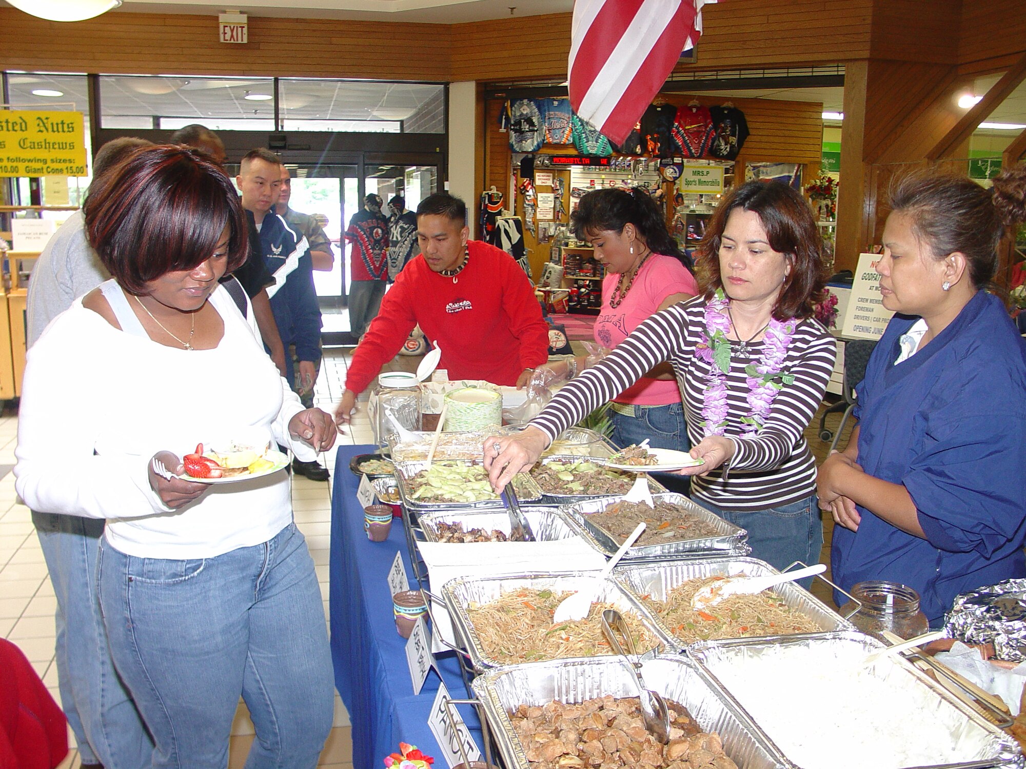 Asian Pacific American Heritage Committee members served food during a food tasting at the BX Saturday to share ethnic dishes and inform others of the annual “Luau” June 30. For tickets, contact your APAH representative.