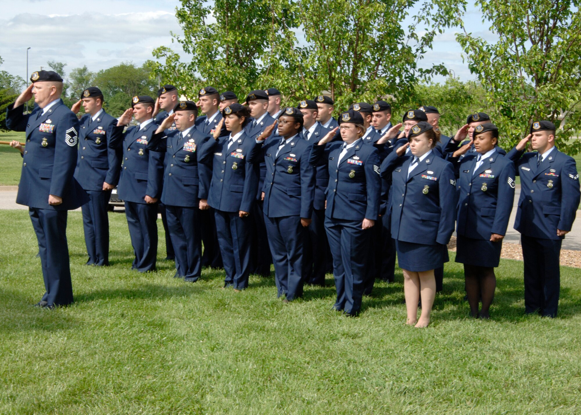 Members of the 22nd Security Forces Squadron render salutes during a retreat ceremony in front of Bldg. 1 May 15. The ceremony commemorates the loss of two Security Forces members and two police officers in the local community in the past year. May 15 marked the beginning of National Police Week. (Photo by Airman Justin Shelton) 

